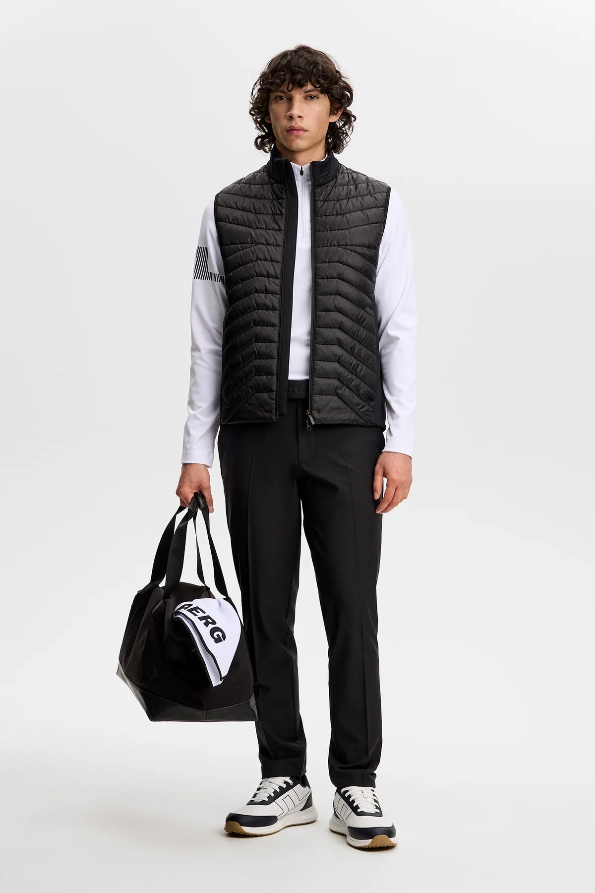 Black tailored trousers worn with a dark belt; straight-leg silhouette and belt loops