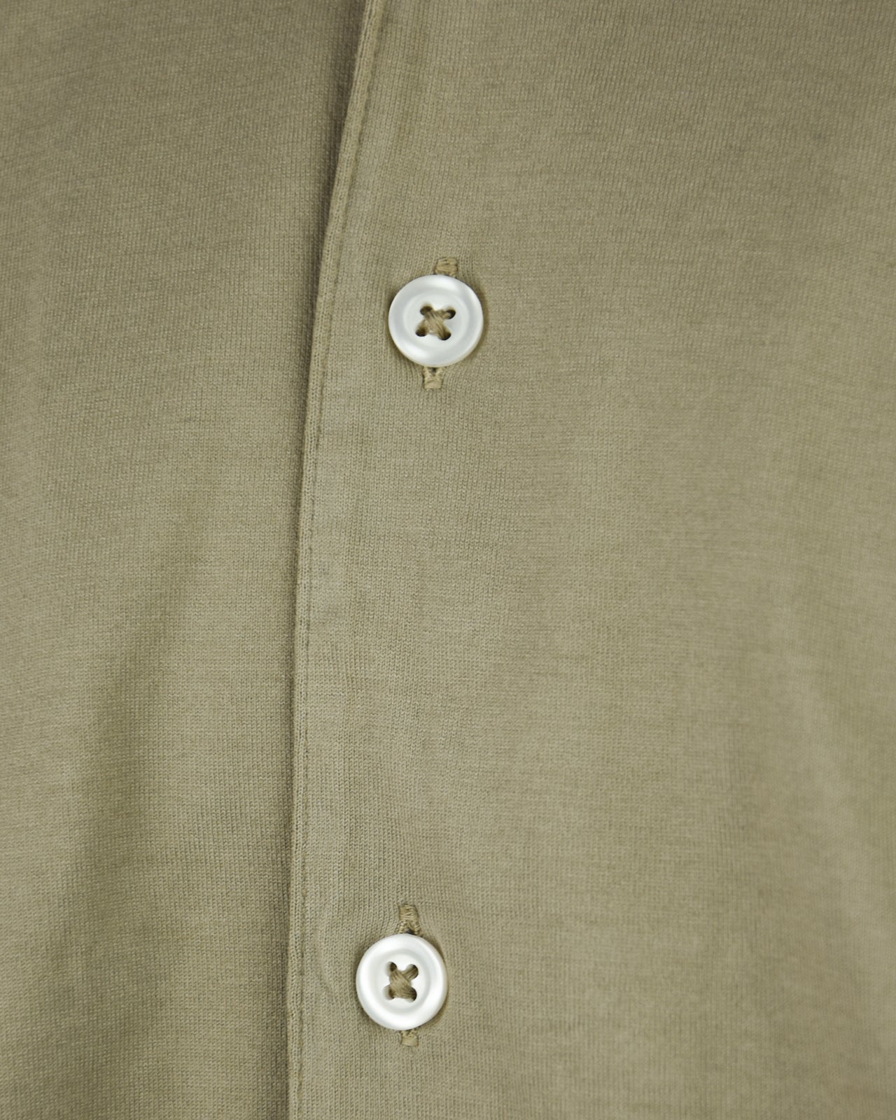 Khaki shirt placket close-up with two white button closures