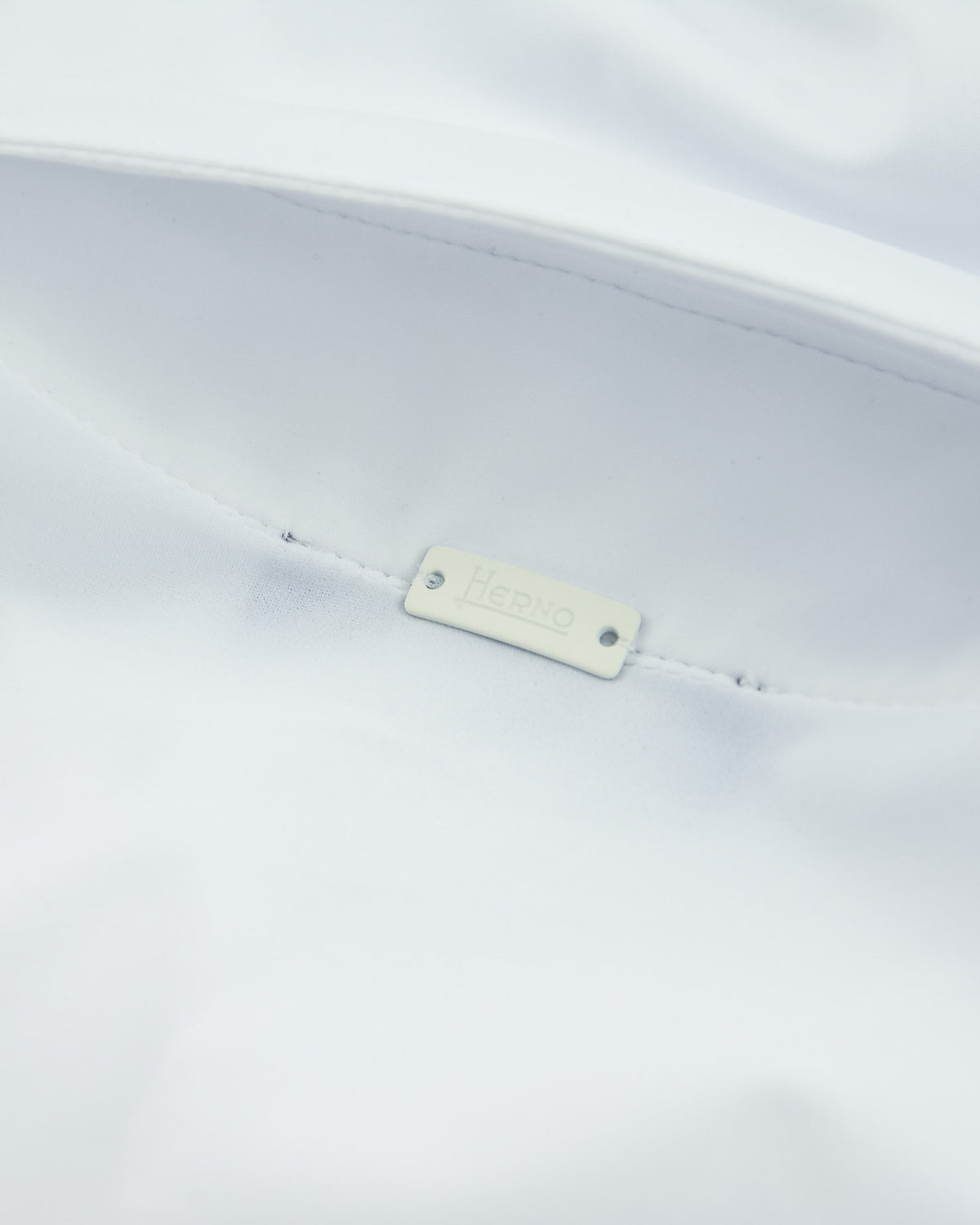 White polo shirt with small interior brand tag at the seam