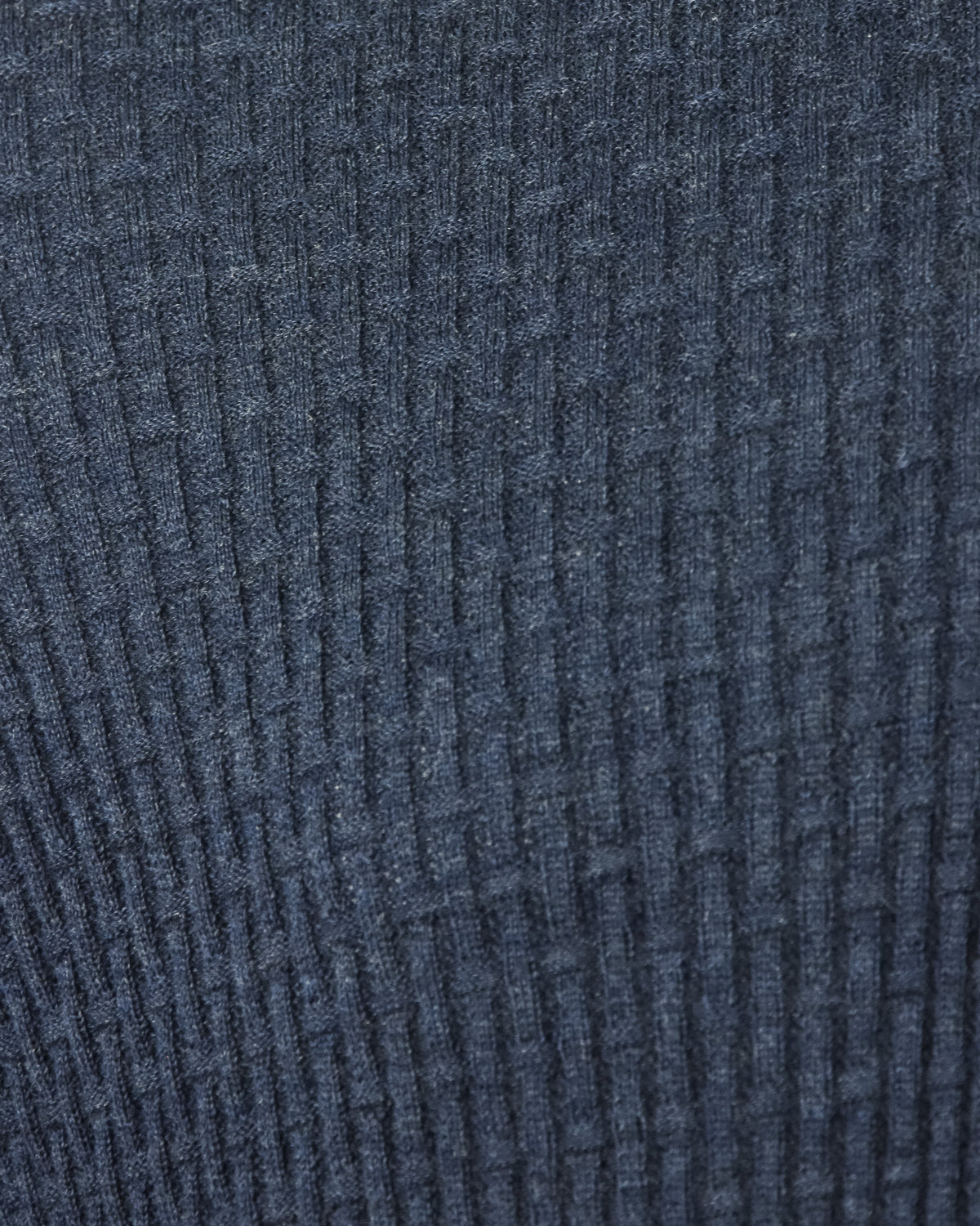 Blue textured knit fabric close-up with grid weave pattern