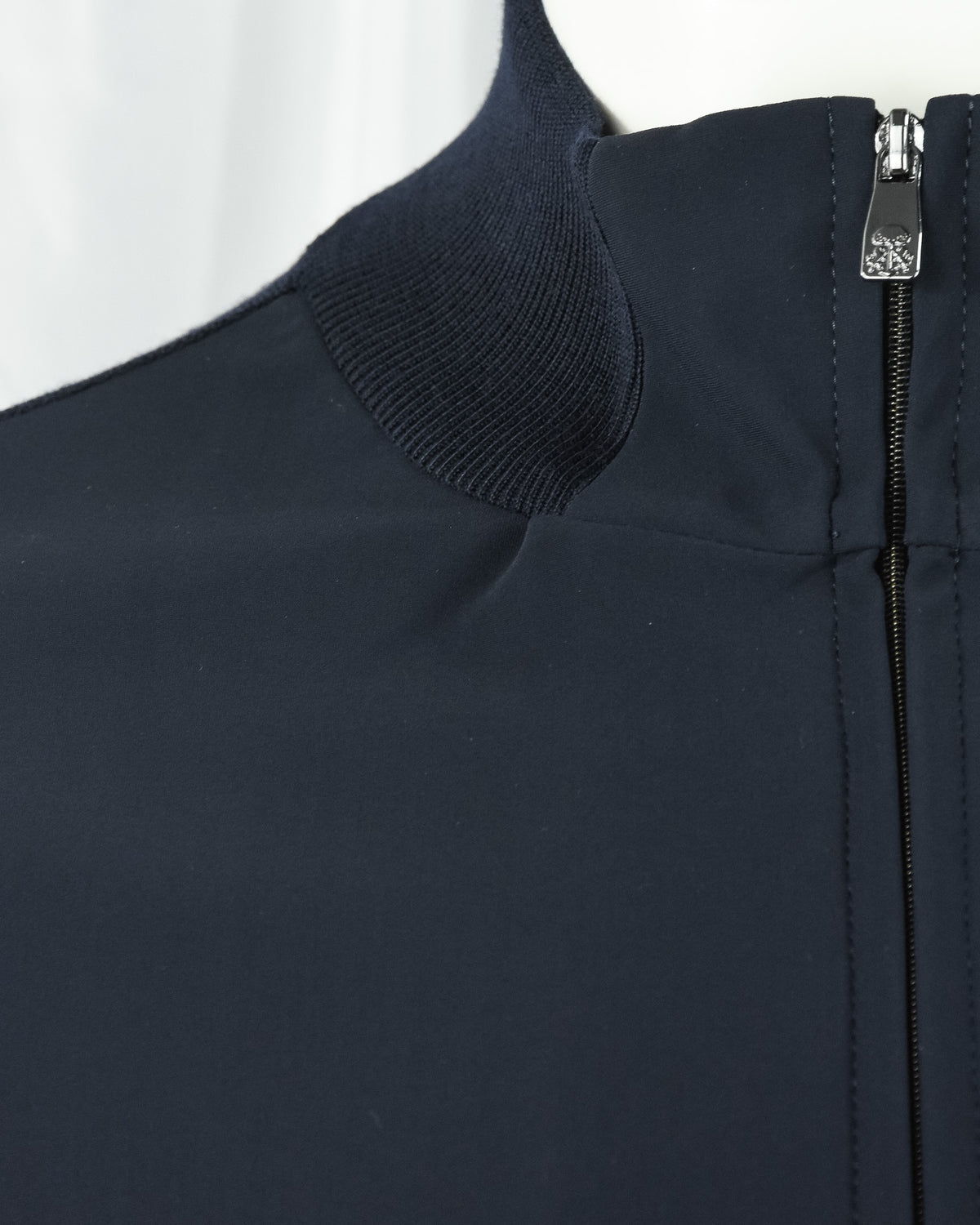 Dark navy stand collar with ribbed knit edge and smooth zip front panel