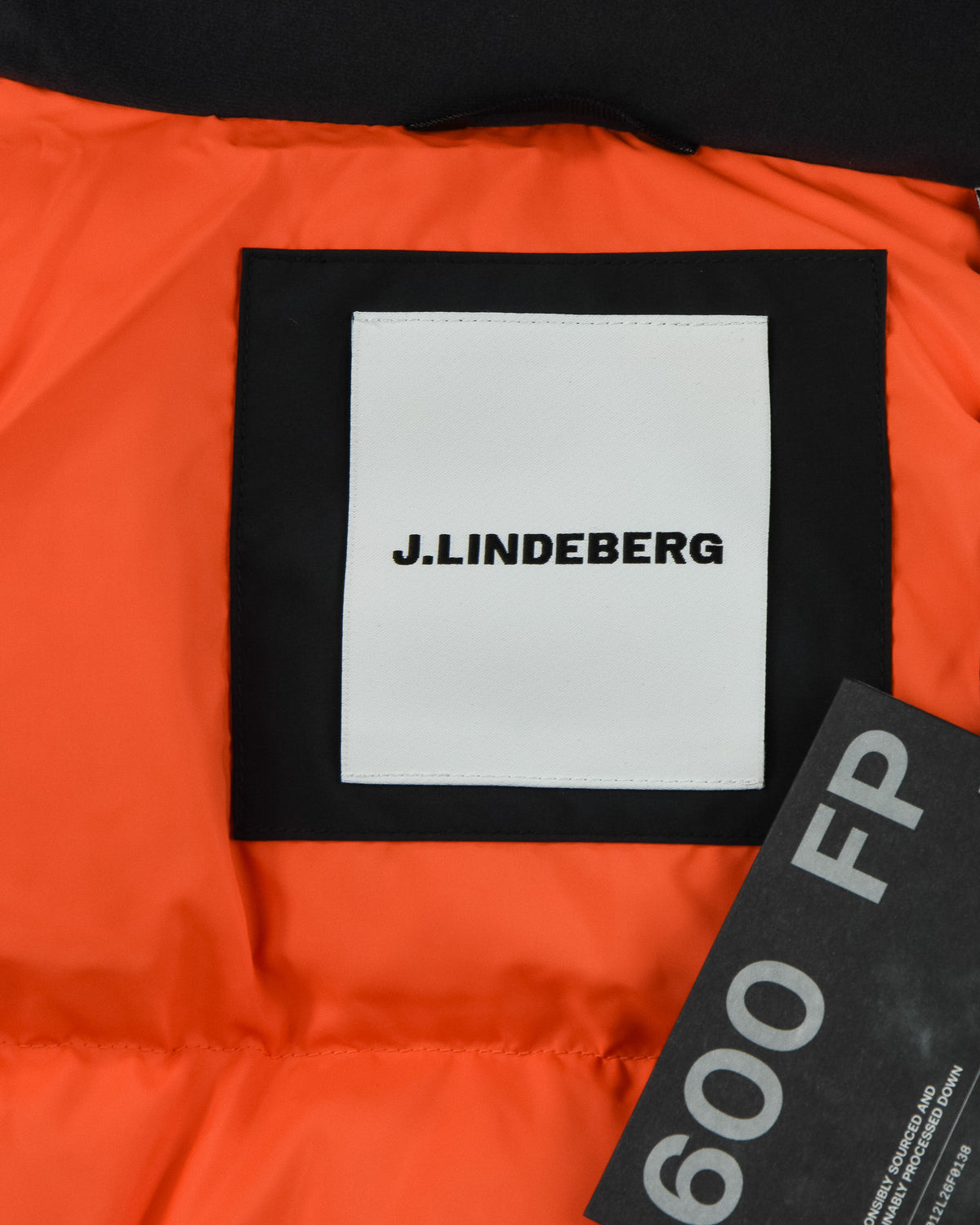 Down parka fabric panel with J.Lindeberg logo patch on black label over orange lining