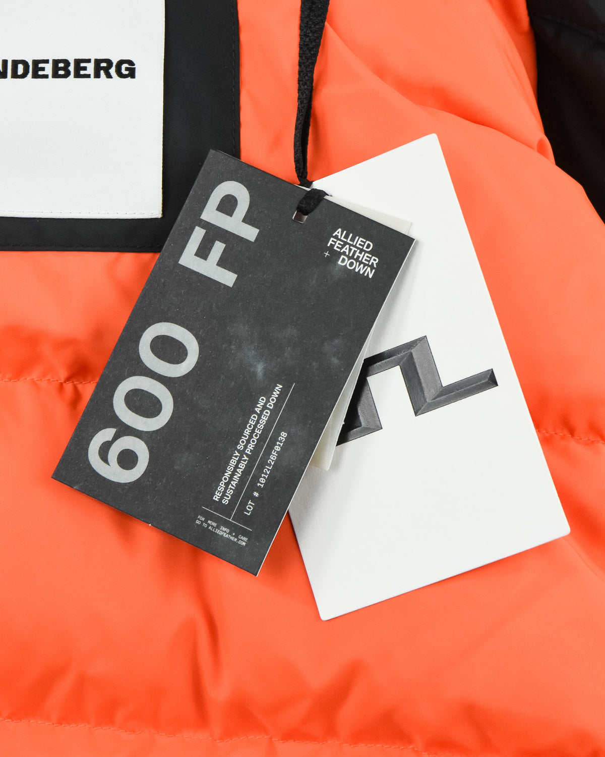 Down parka with attached 650 FP tag and white brand tag on orange fabric