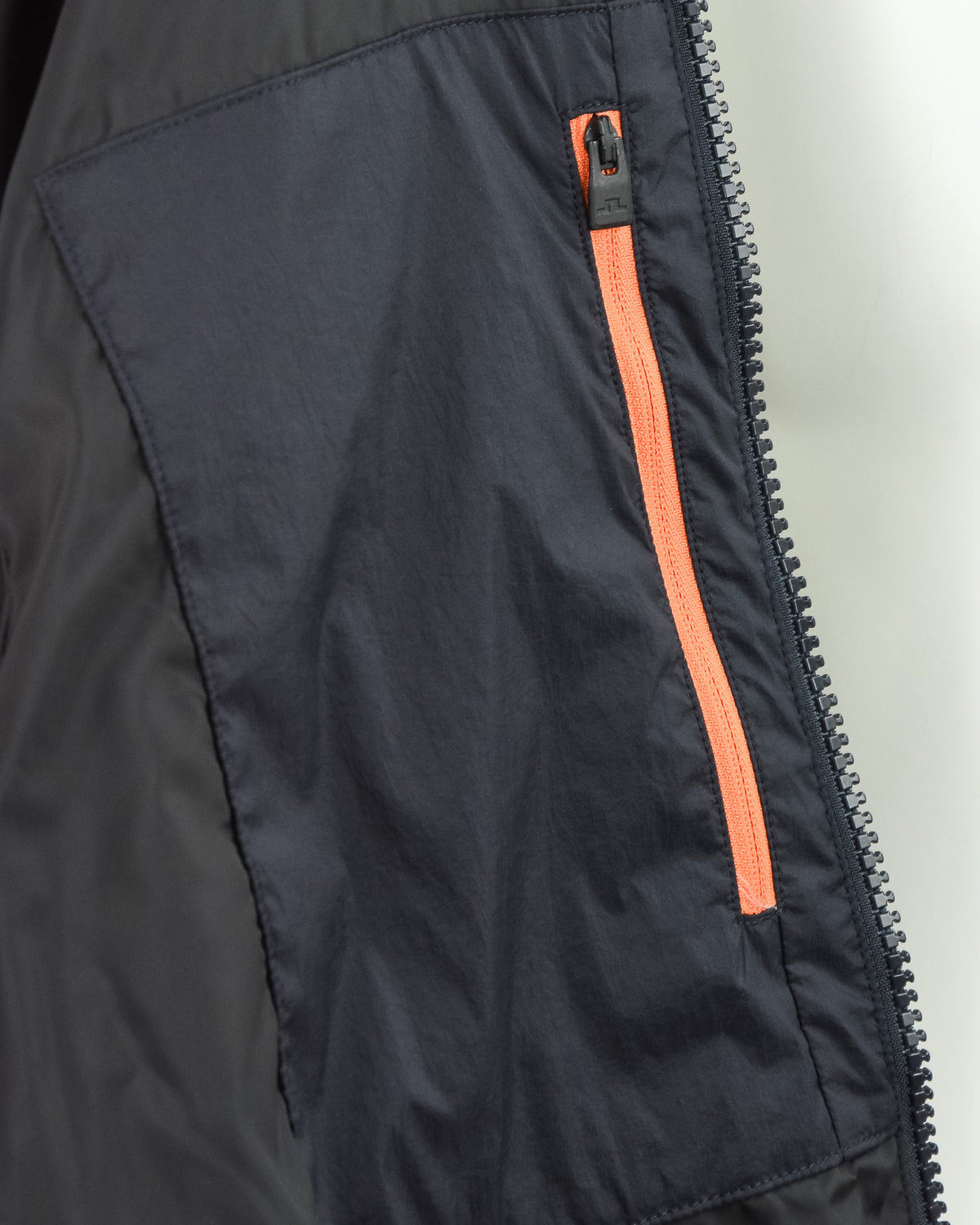 Dark navy crinkle down jacket panel with orange contrast zipper