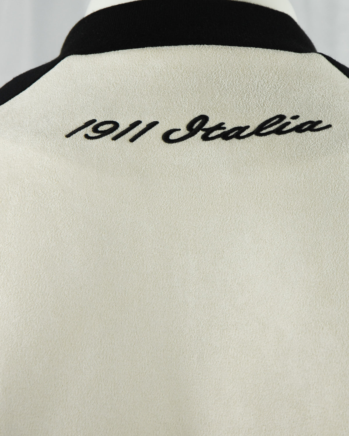 Fila Isaac jacket back close-up with “Isaac” script and black ribbed collar
