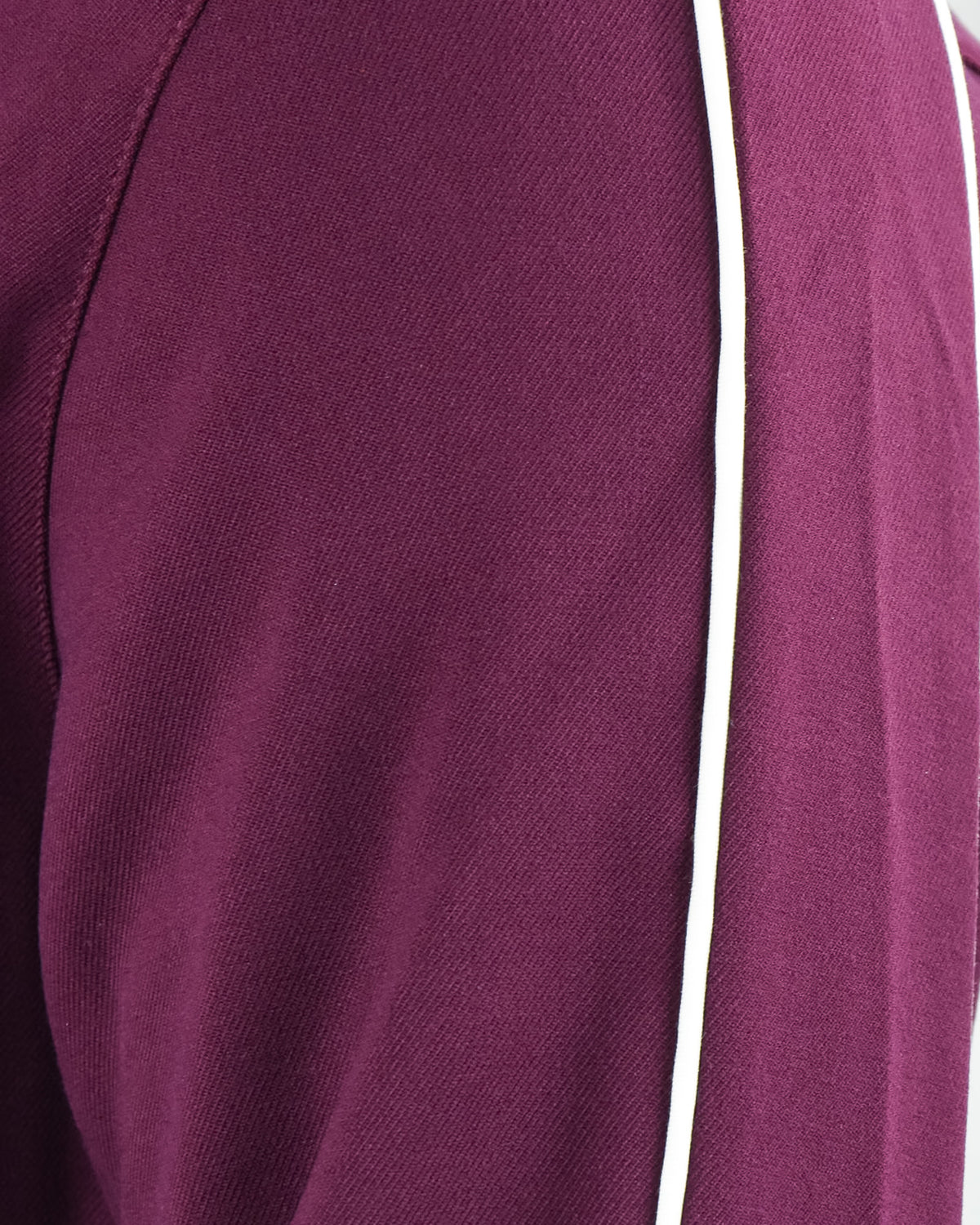 Close-up of purple track jacket fabric panel and textured seam stitching