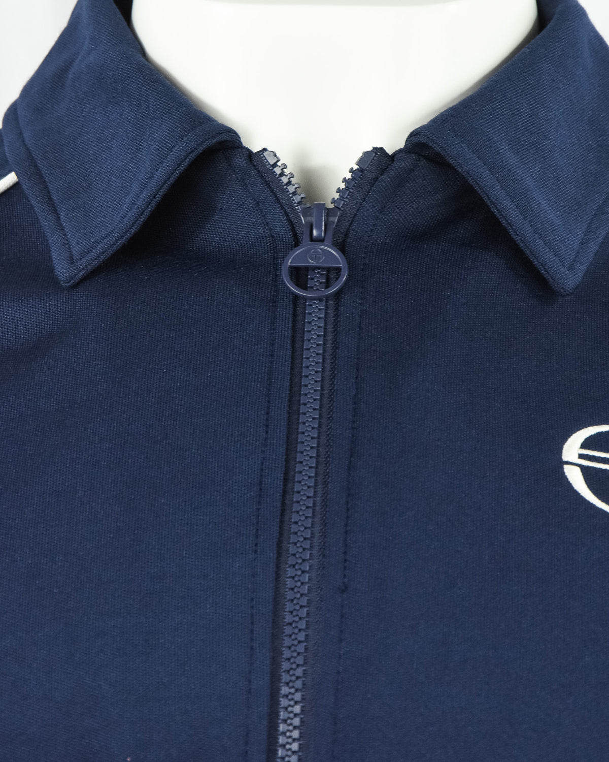 Navy track top stand collar with full zip and circular logo badge
