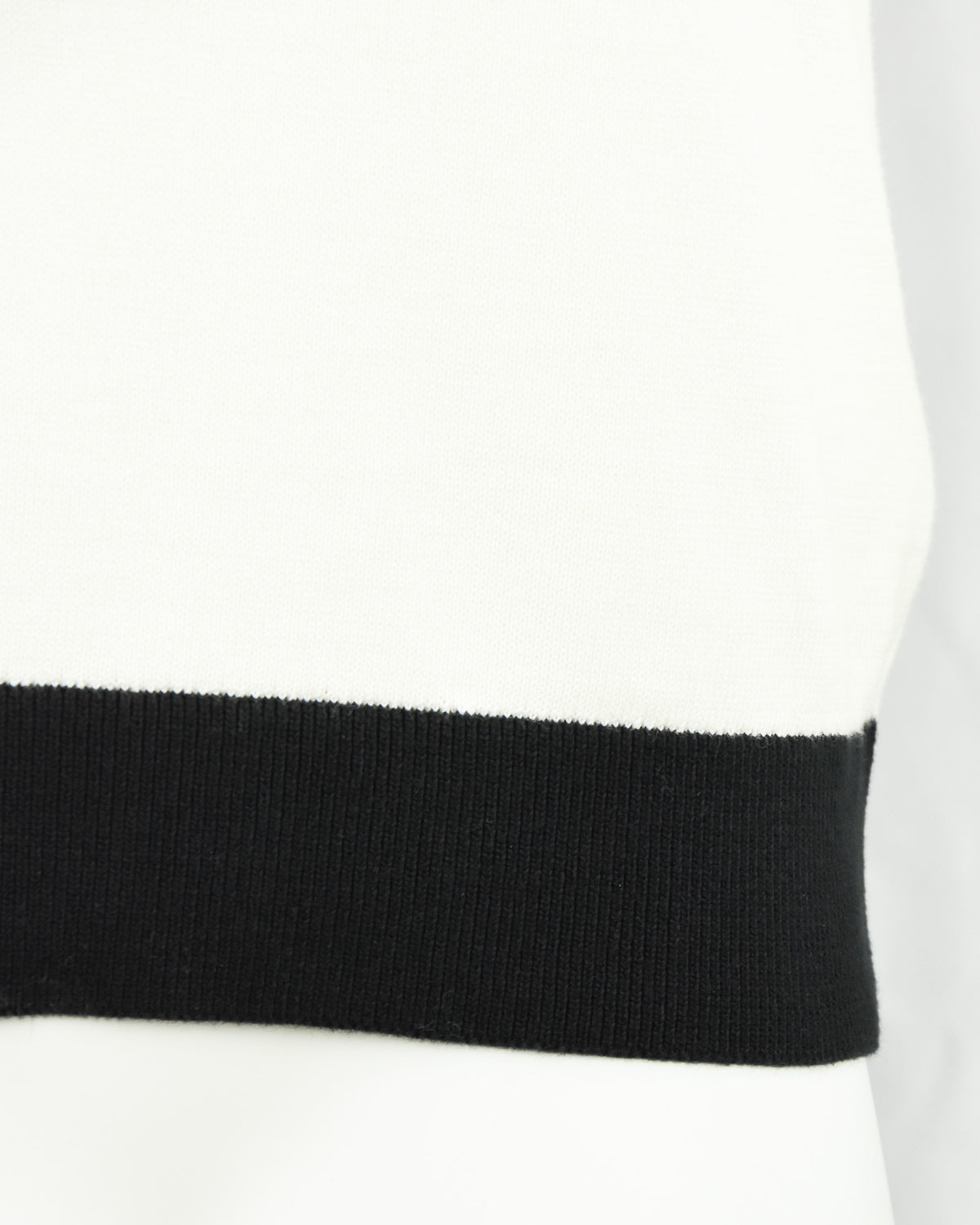 Cream knitted polo sleeve cuff and hem with black ribbed band.