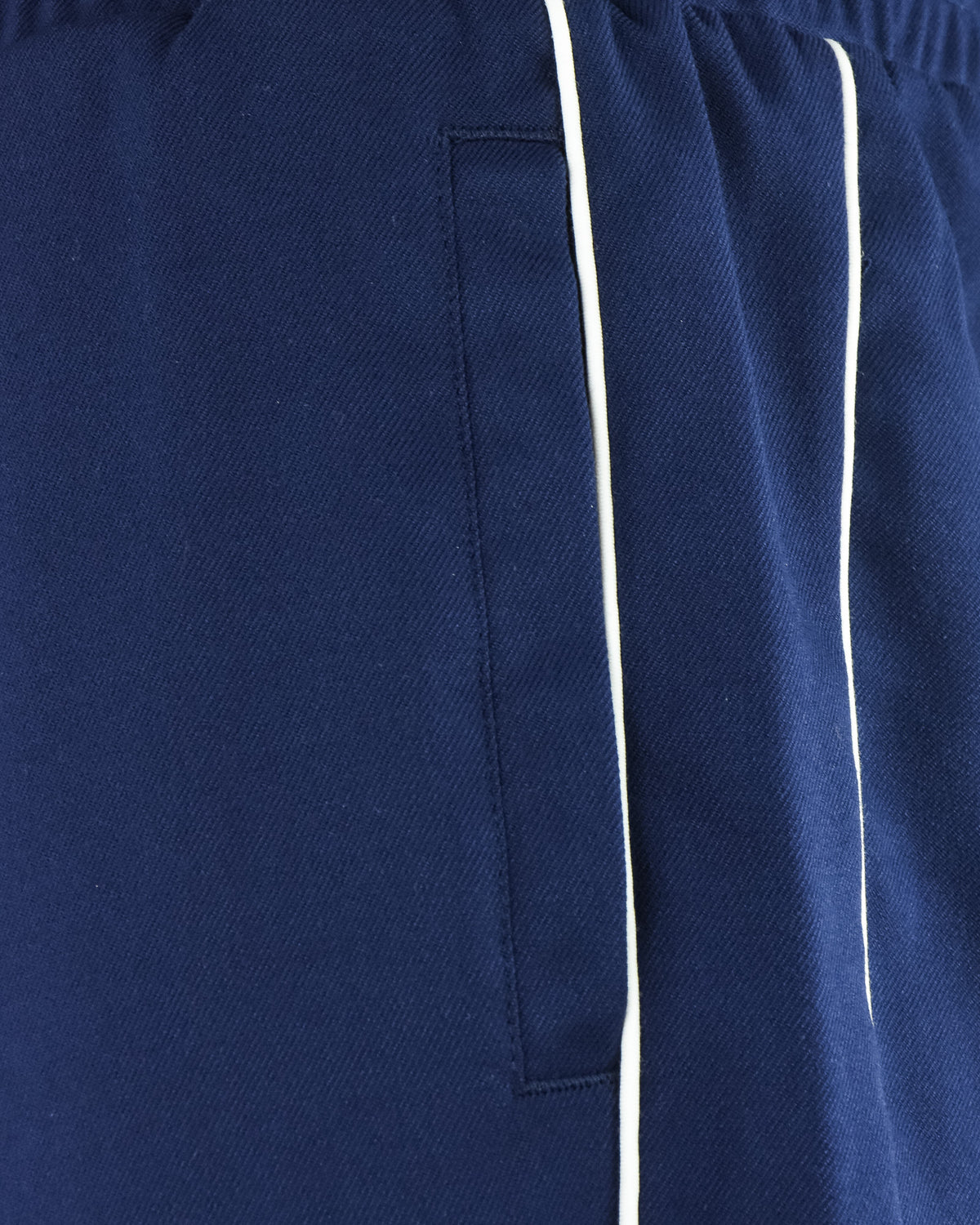 Navy track pants detail with side pocket and white piping stripe
