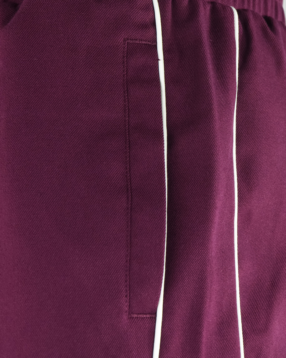 Burgundy track pants pocket with vertical white stripe detail
