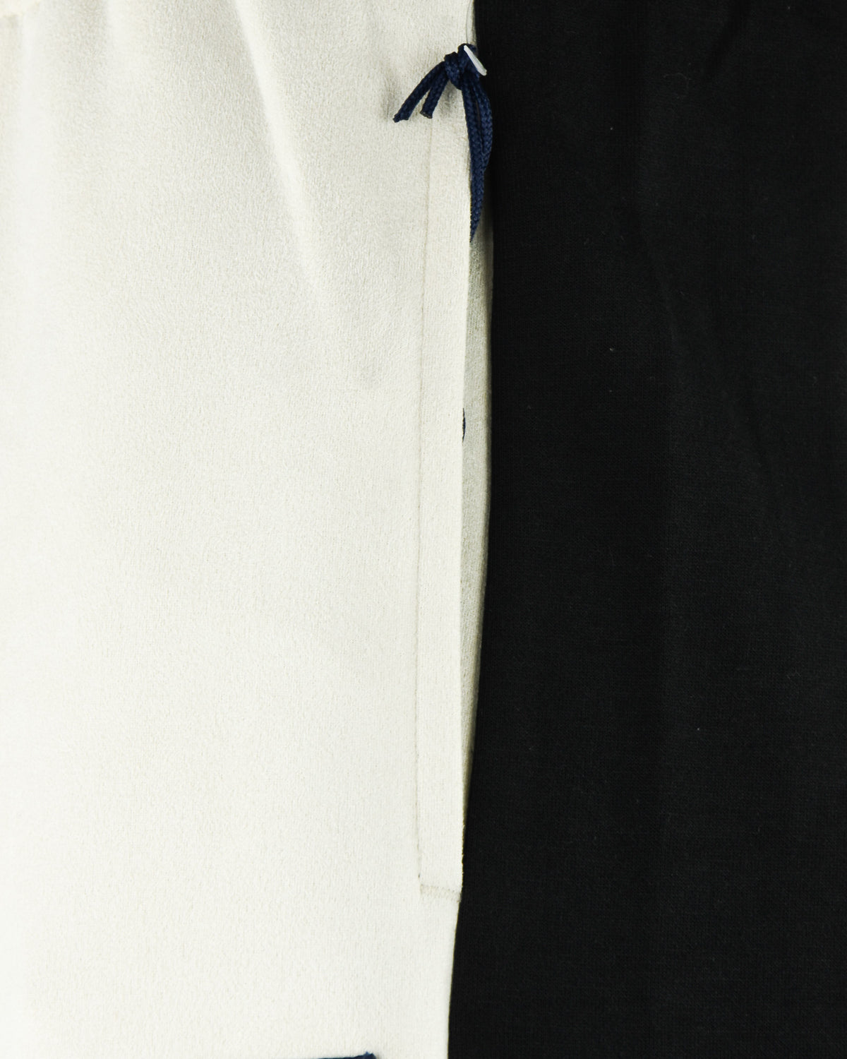 Cream track pants with black side panel and blue drawstring tie at waistband