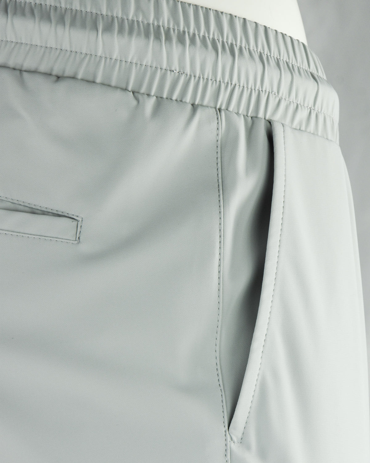 Stone grey tech pants side pocket and elastic waistband detail