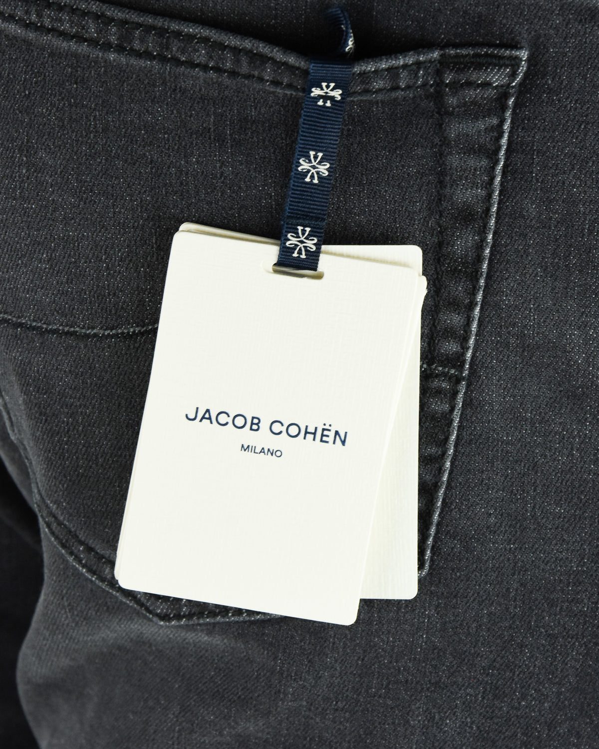 Jacob Cohen Milano hang tag attached to dark grey denim jeans pocket.