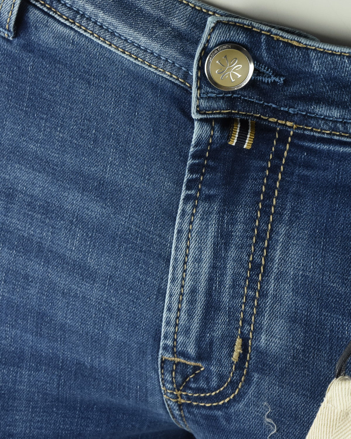 Blue denim jeans with branded button closure and stitched waistband