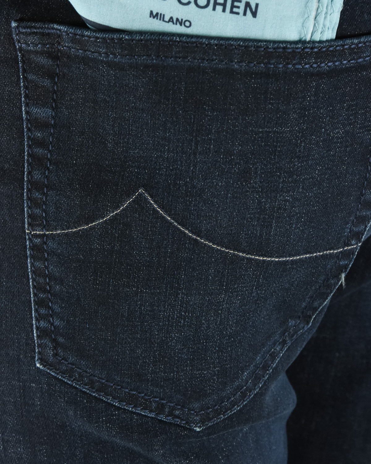 Curved back pocket with dark blue denim stitch lines and seam detail.