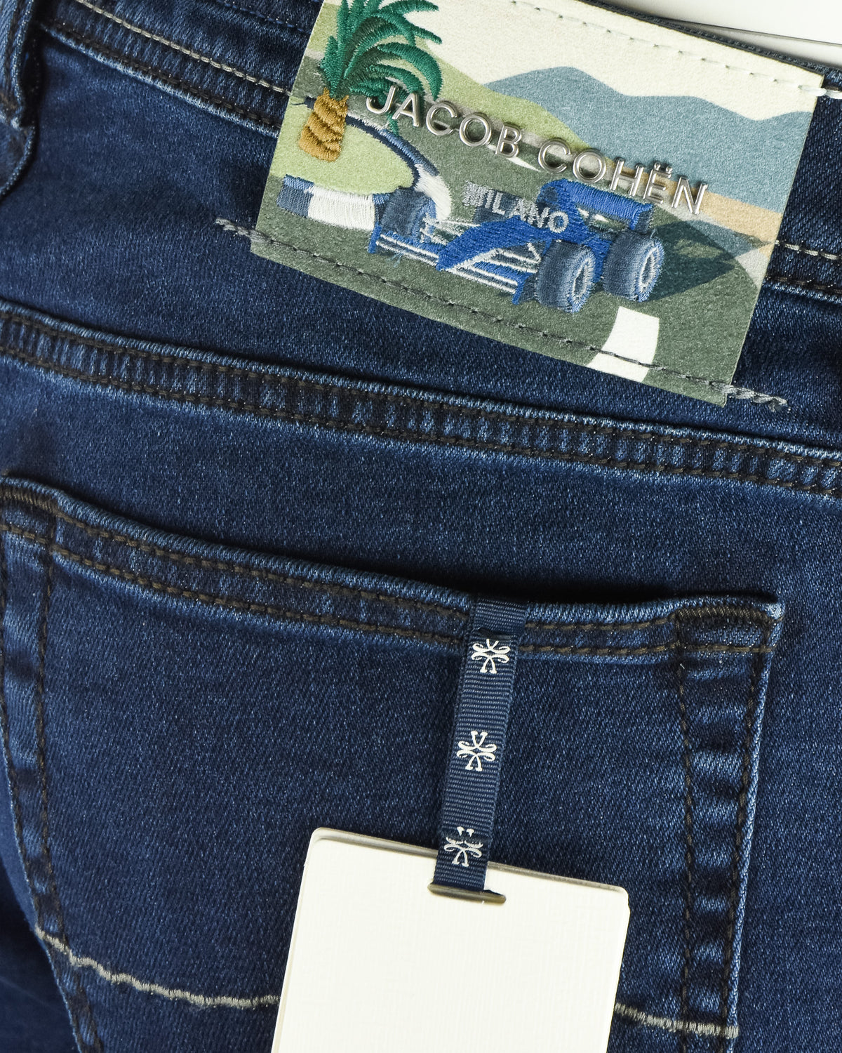 Dark blue denim jeans with logo patch on waistband and belt loop area