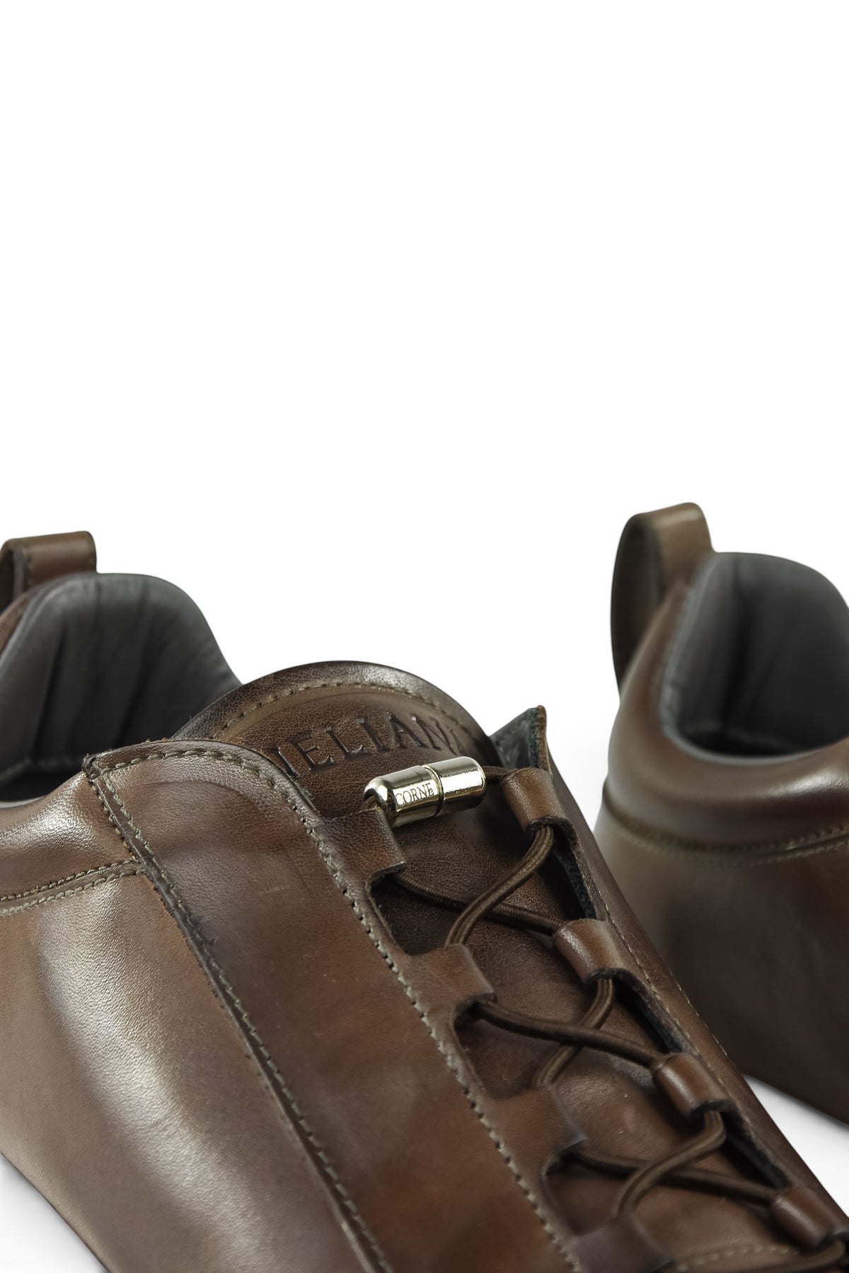 Brown leather low-top trainer tongue detail with metal toggle and lace eyelets