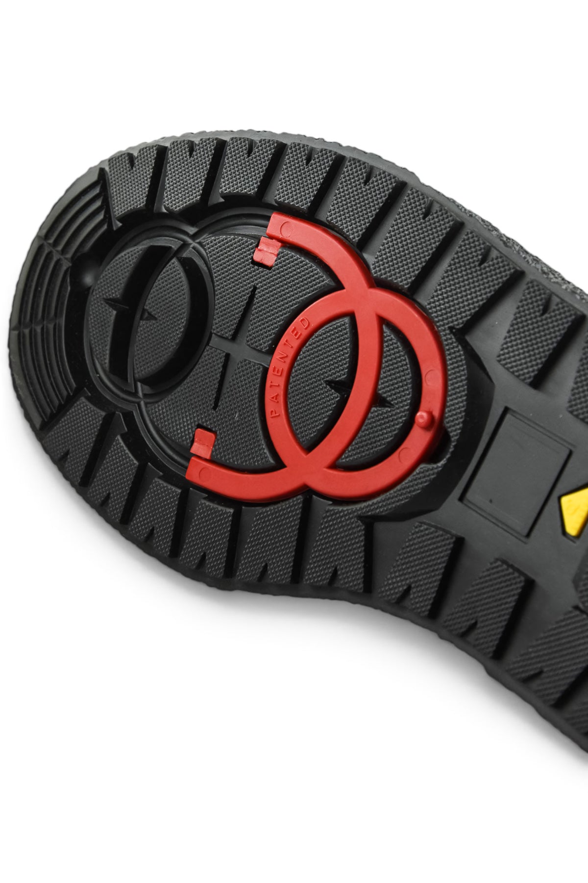 Black outsole tread close-up with red ring grip and textured channels