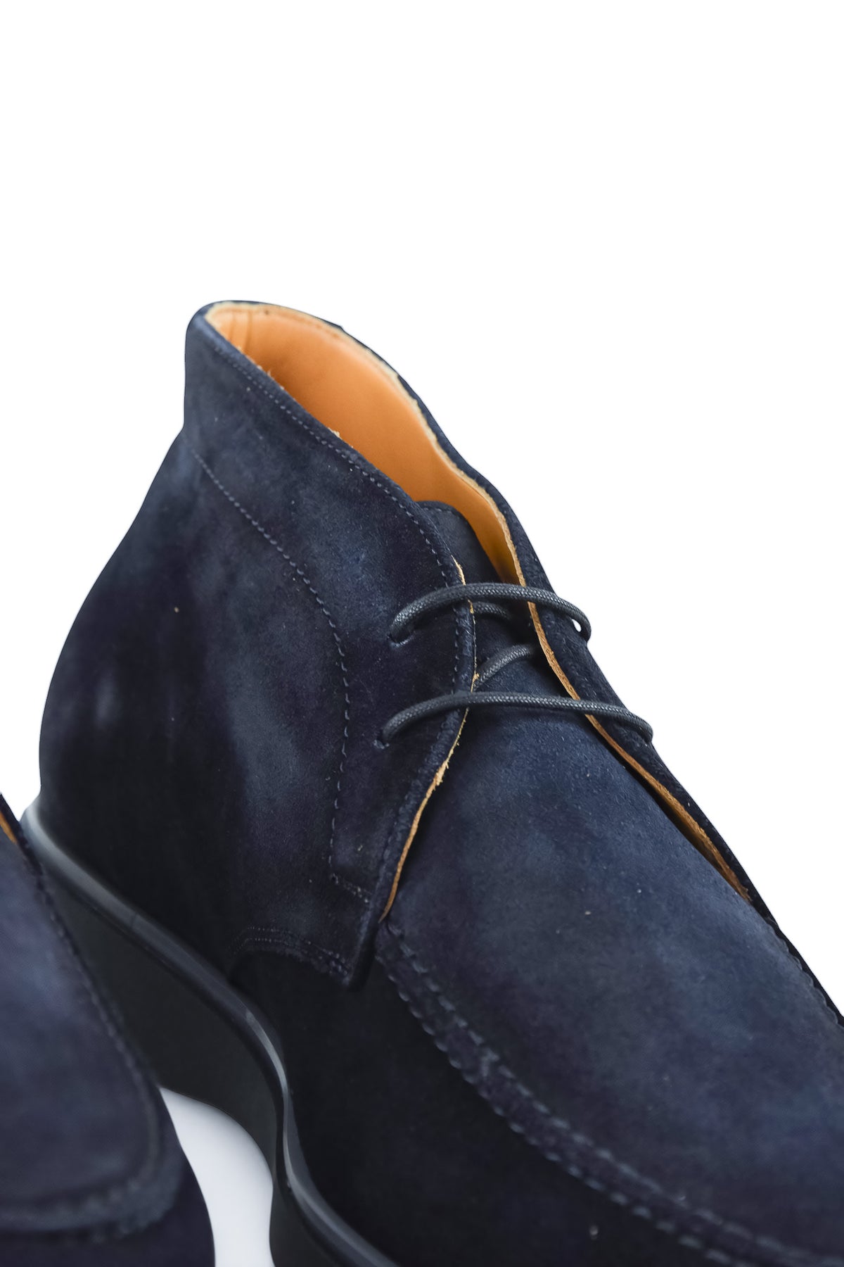 Blue suede chukka desert boot with lace-up front and tan lining at collar.