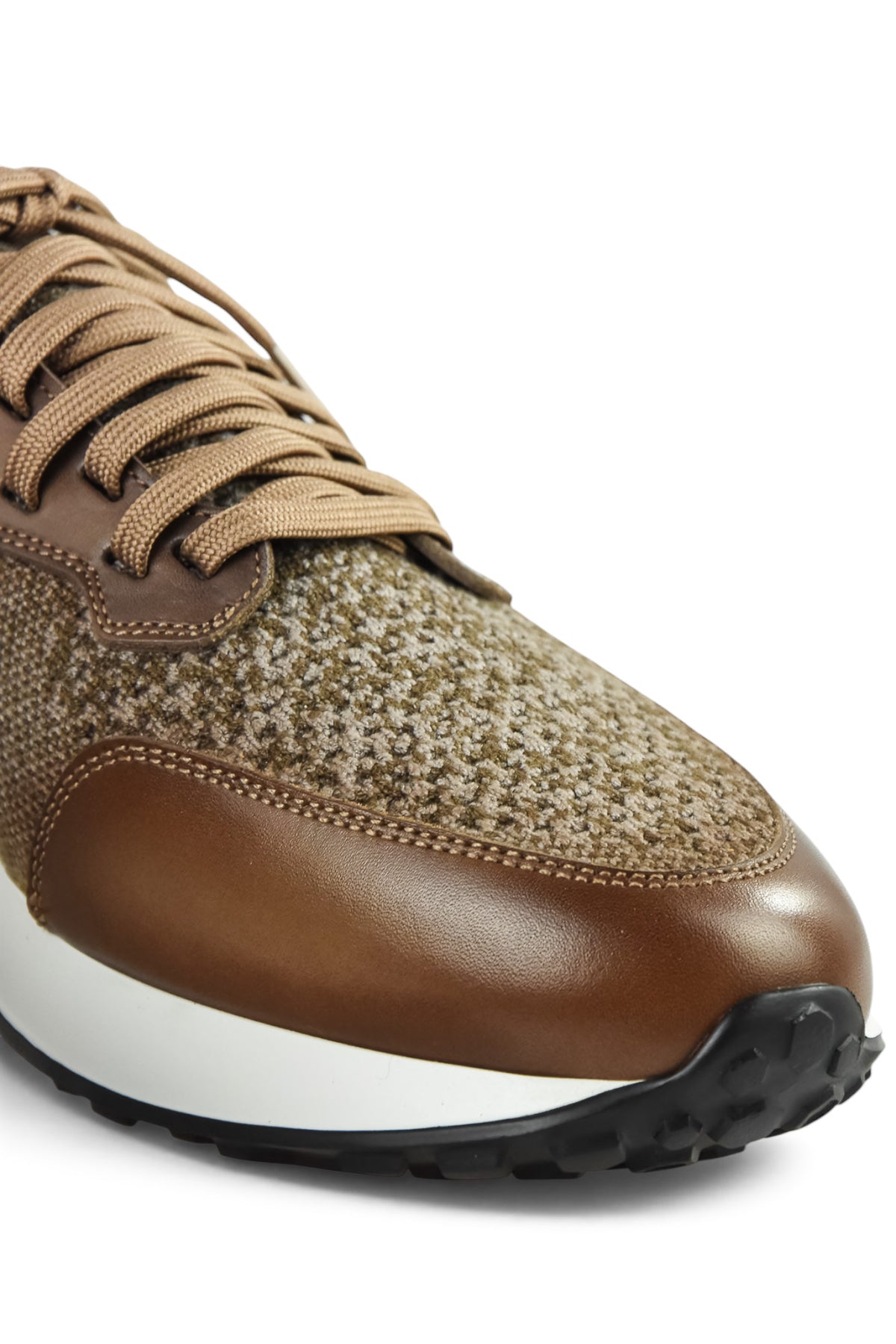Front close-up of tan lace-up knit trainer with brown leather toe cap and grippy sole