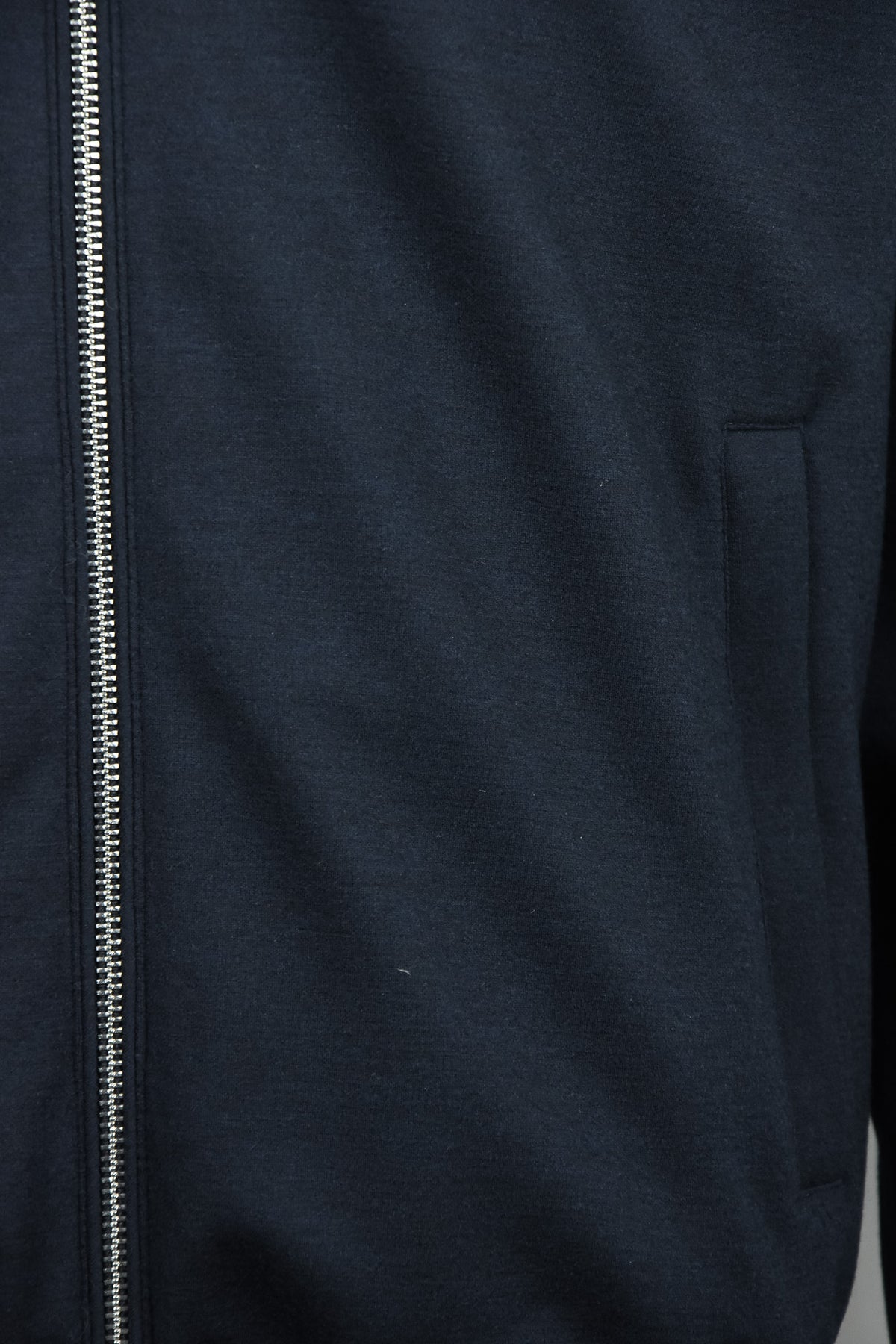Dark blue padded wool jacket with center zipper and welt chest pocket