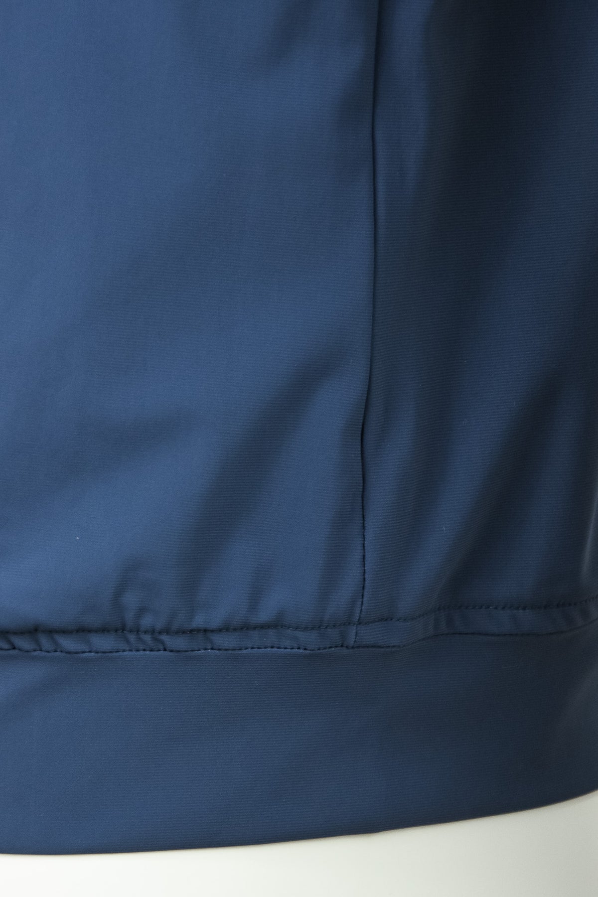 Blue tech stretch jacket hem with stitched seam and elastic waistband