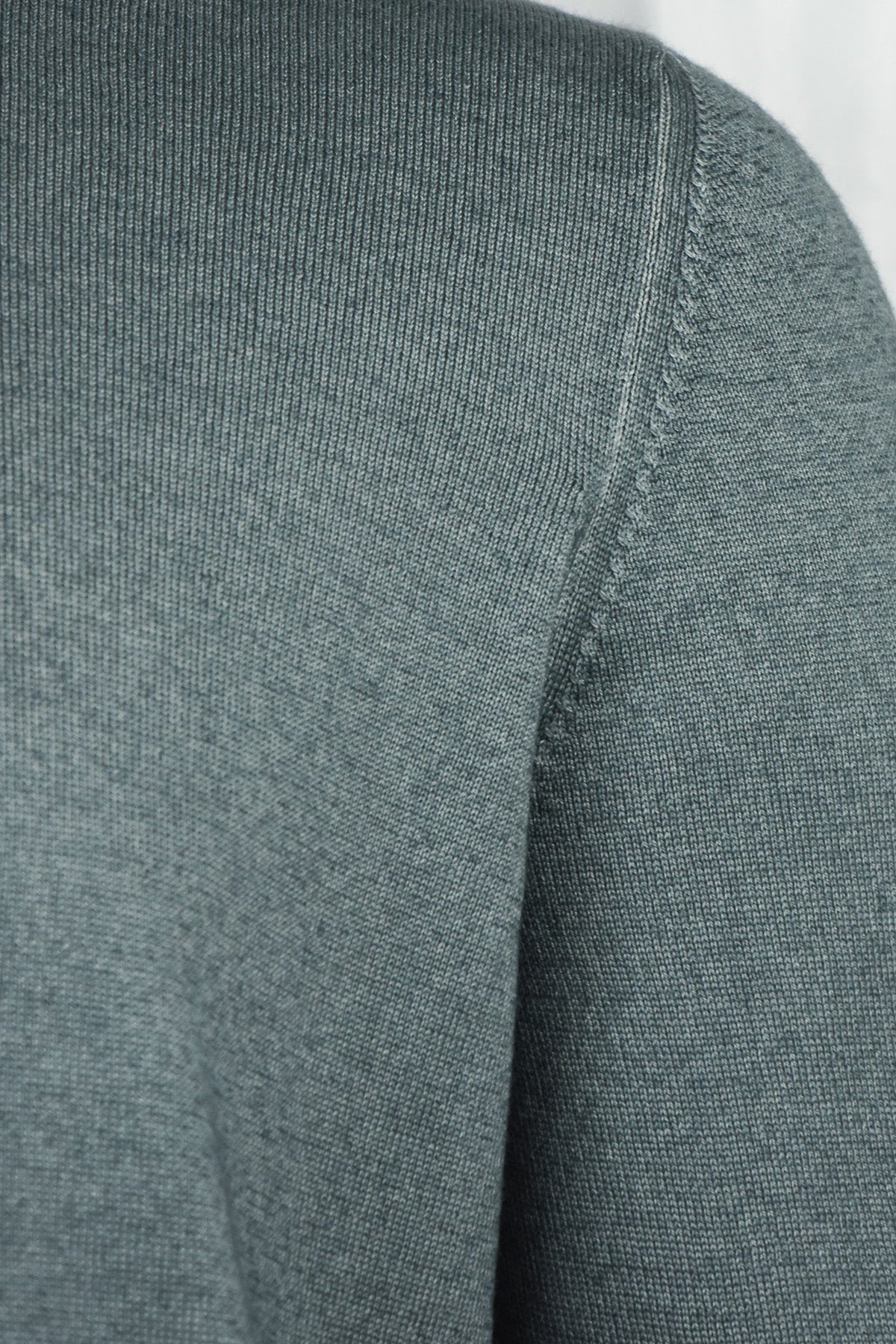 Petrol blue knit cardigan with textured shoulder seam and ribbed stand collar.