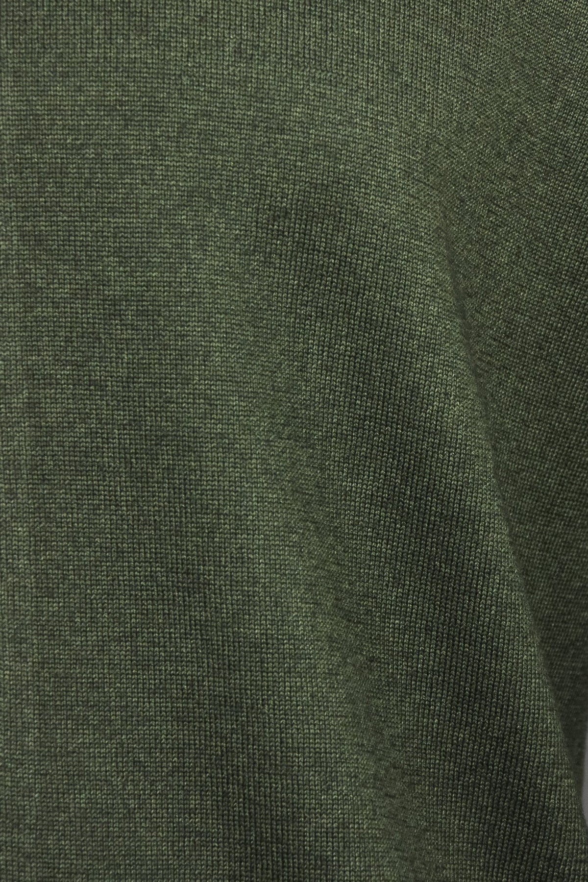 Bottle green knit cardigan fabric close-up with subtle speckled texture