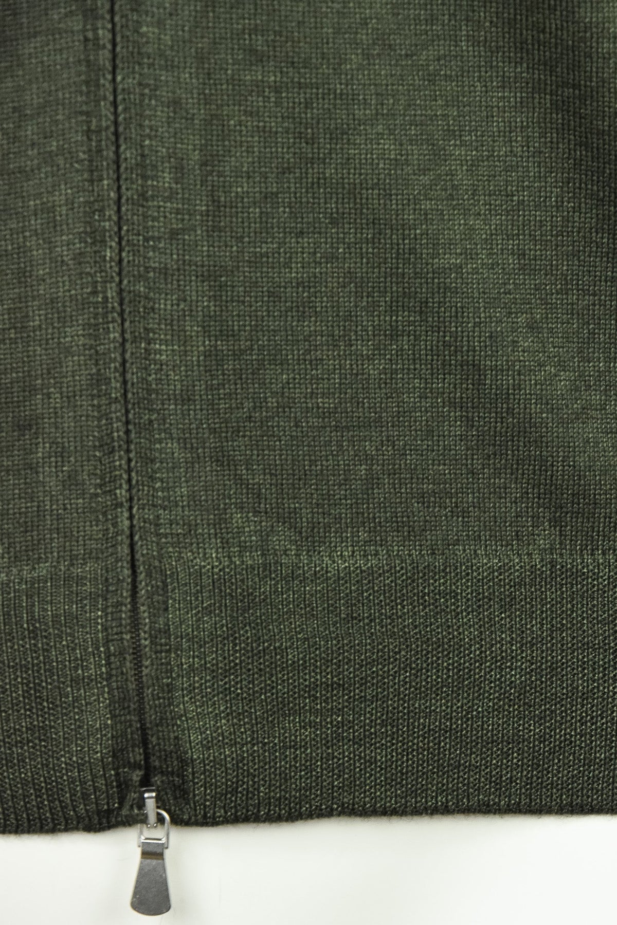 Bottom front view of bottle green cardigan with zipper and knit hem detail