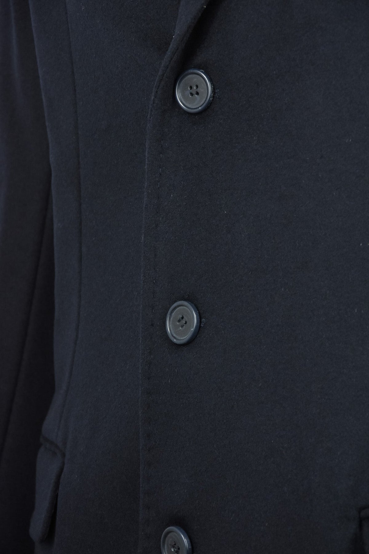 Overcoat front detail with three dark buttons on wool-cashmere fabric