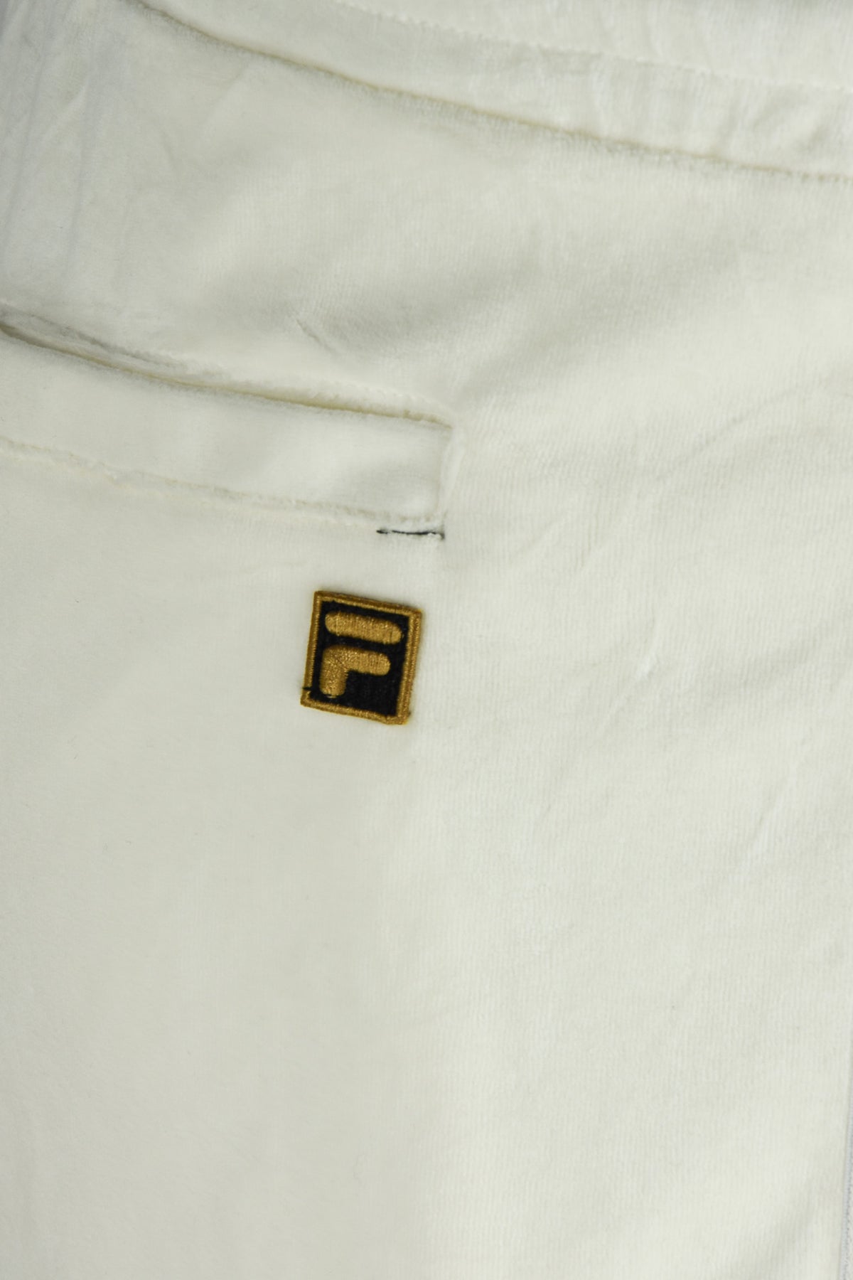 White velour track pants with embroidered F logo patch and seam detail