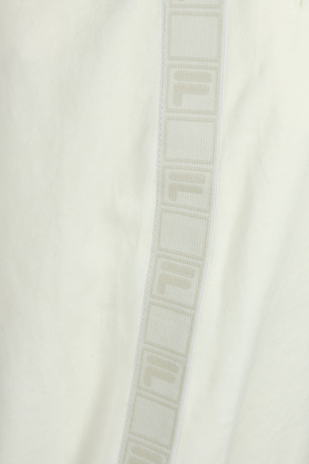 White velour track pants with vertical FILA tape stripe along the side