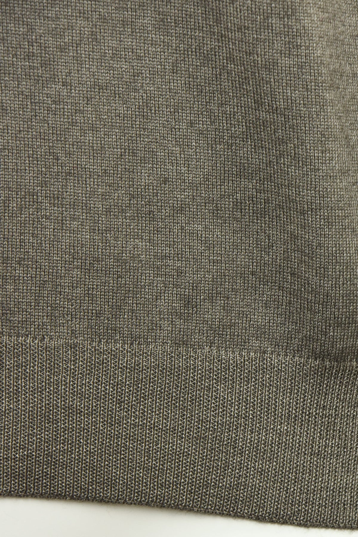 Close-up of the jumper's ribbed hem and knit texture