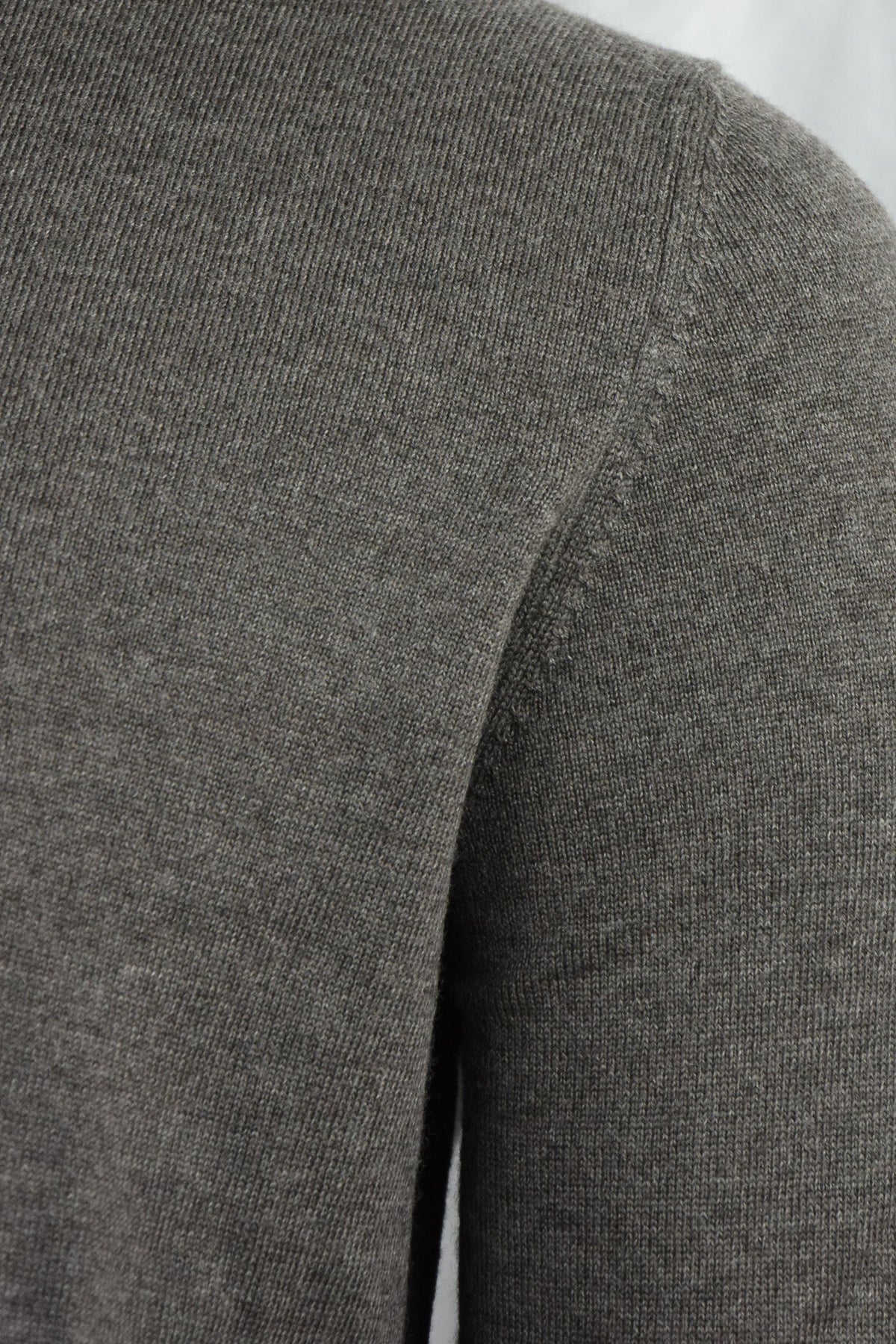 Close-up of the cardigan's gray knit fabric and shoulder seam