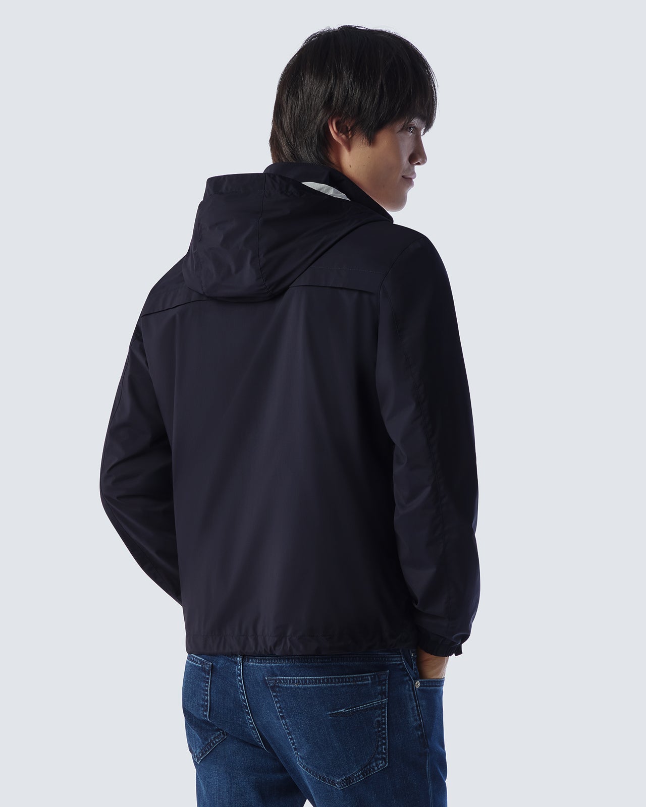 Navy hooded jacket from back view with hood and adjustable hem