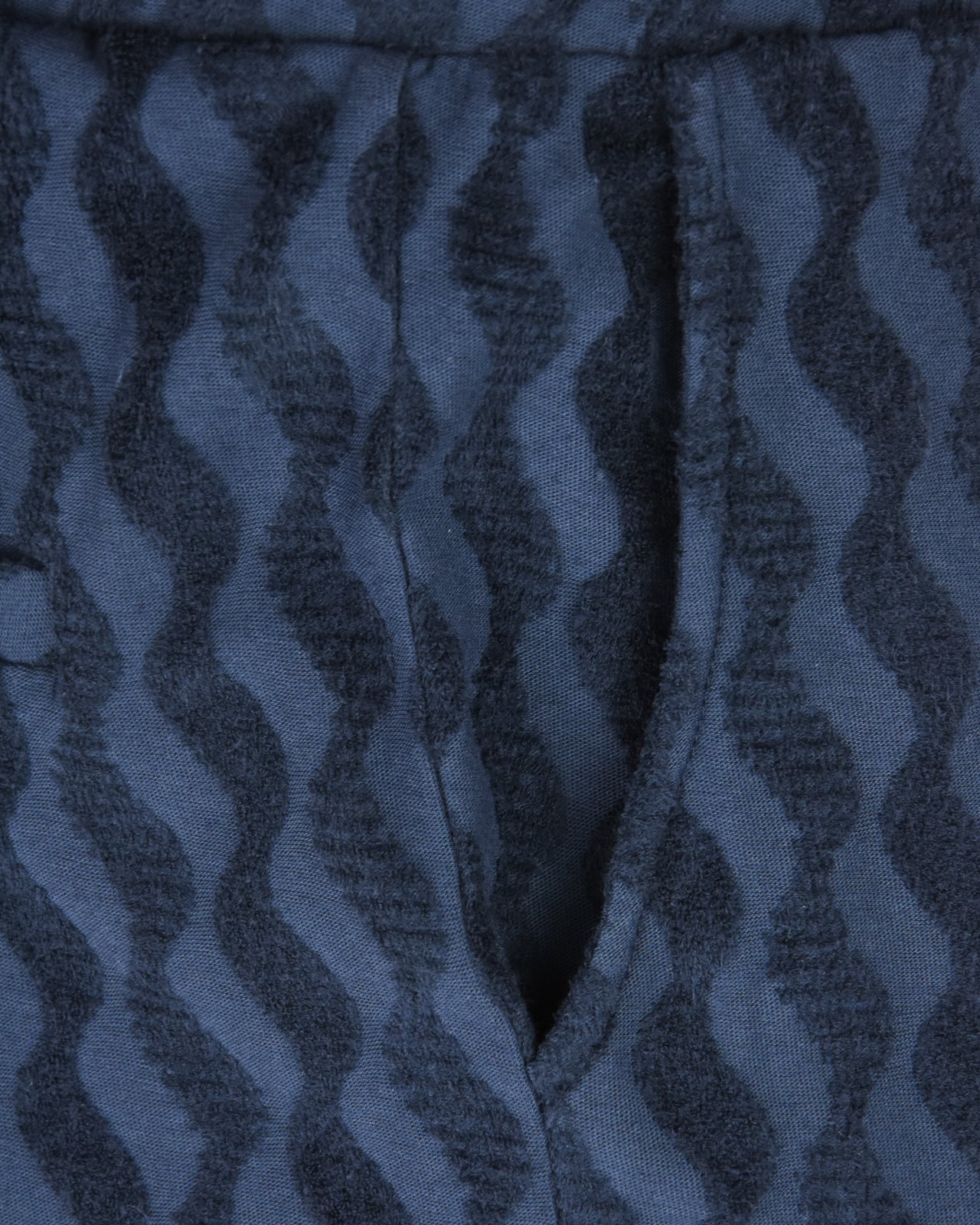 Blue jacquard terry fabric close-up with dark irregular wave pattern