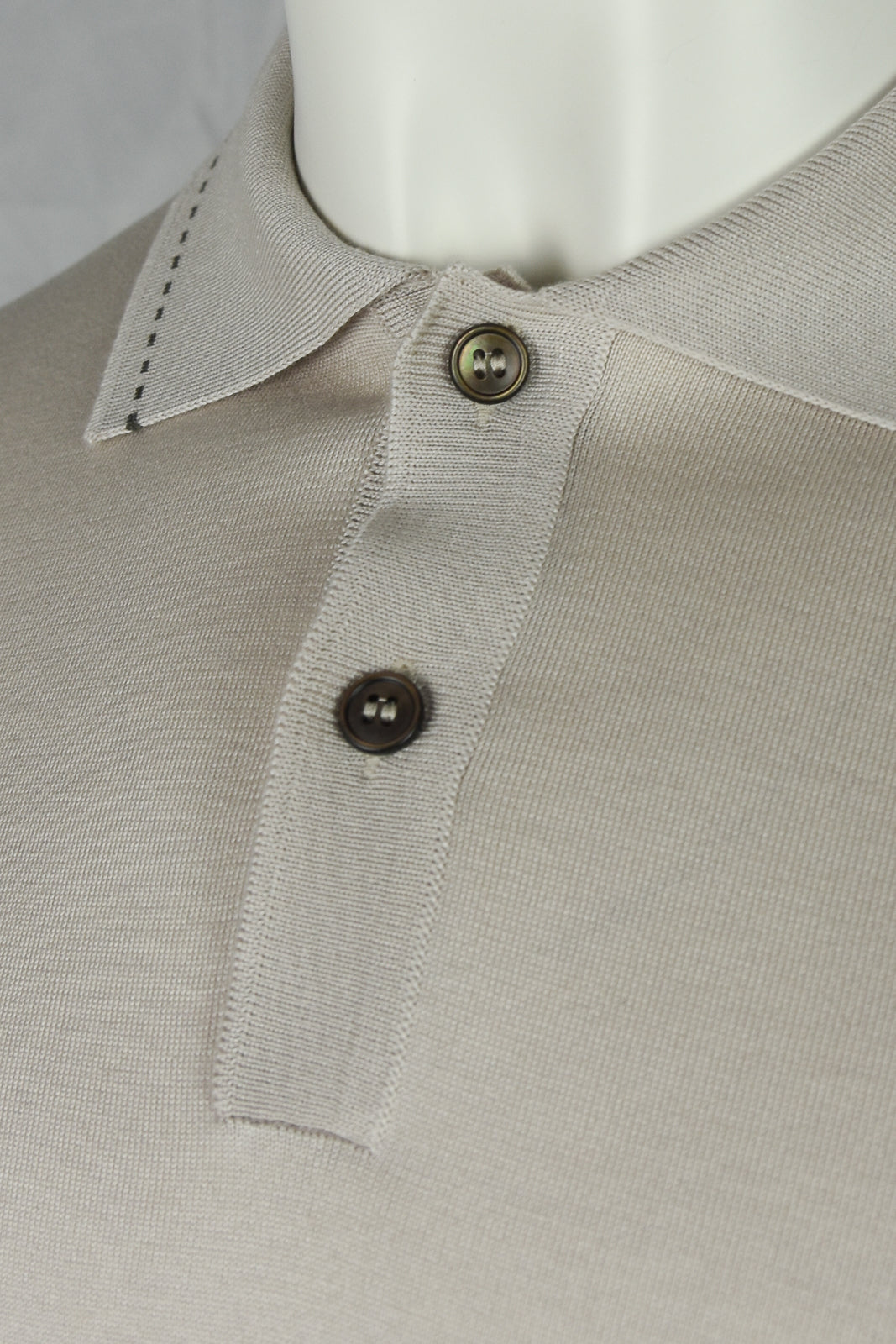 Stone beige polo collar with two dark buttons and contrast-stitched placket