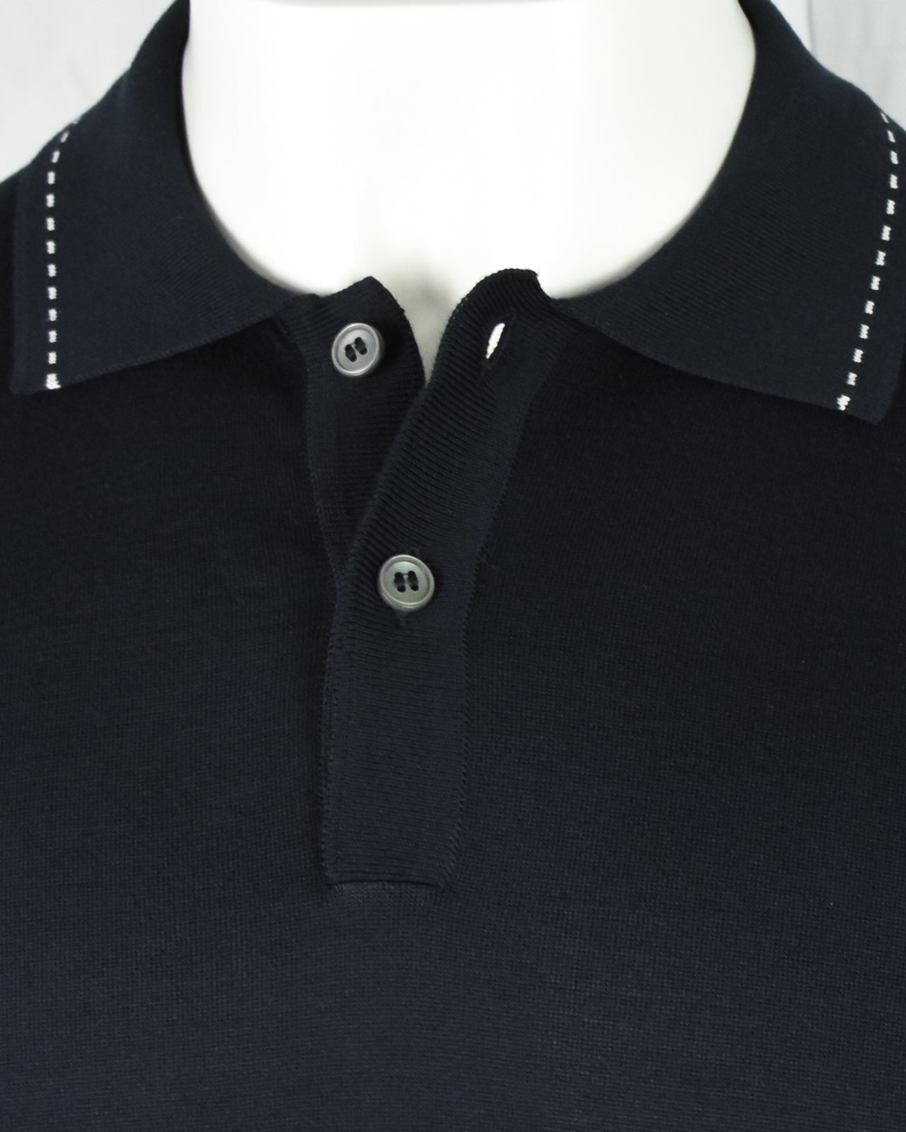 Navy polo collar with two-button placket and contrast stitch detail at yoke
