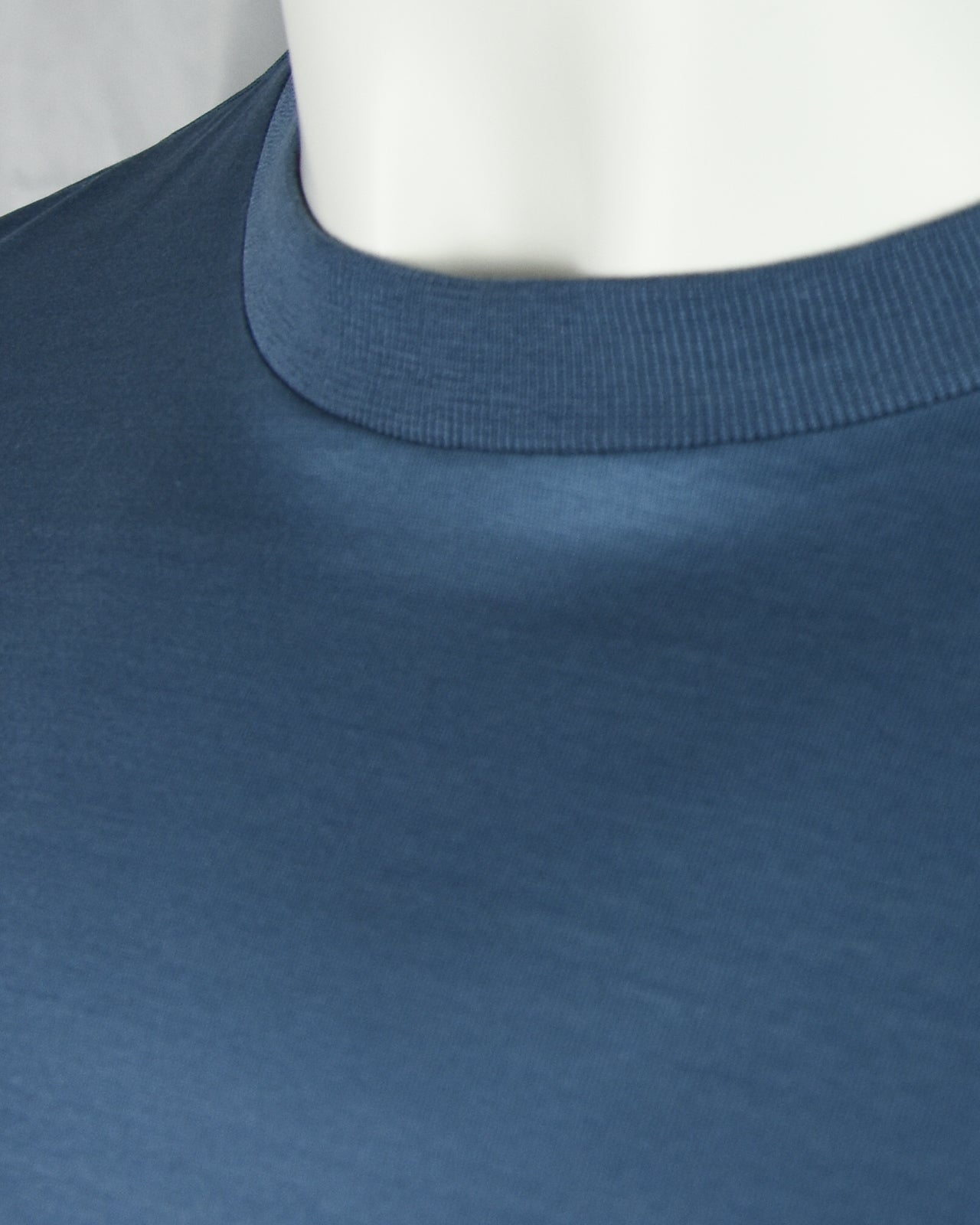 Deep blue high neckline ribbed collar on a short sleeve t-shirt, close-up.