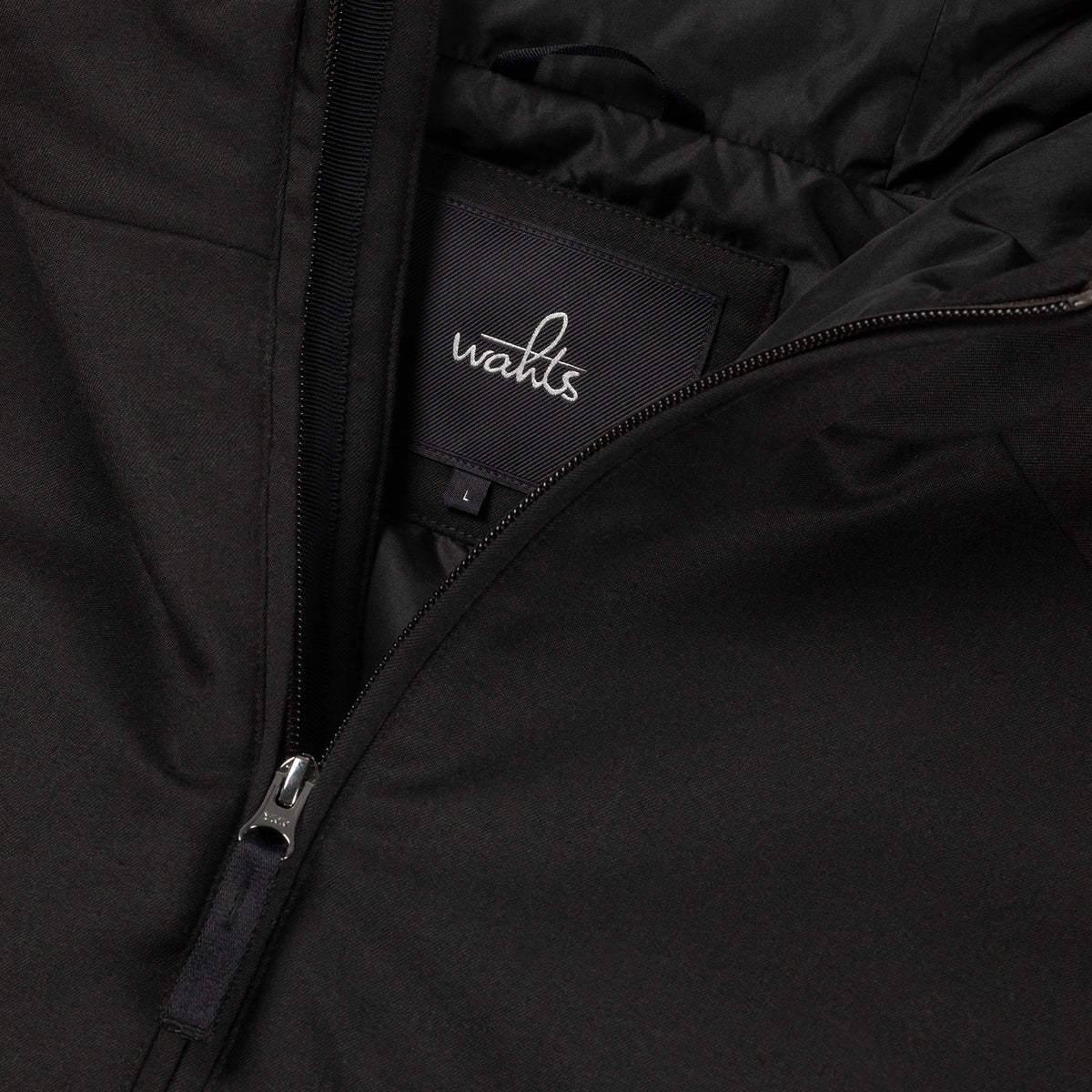 WAHTS Rodan hooded jacket logo patch and angled zipper close-up