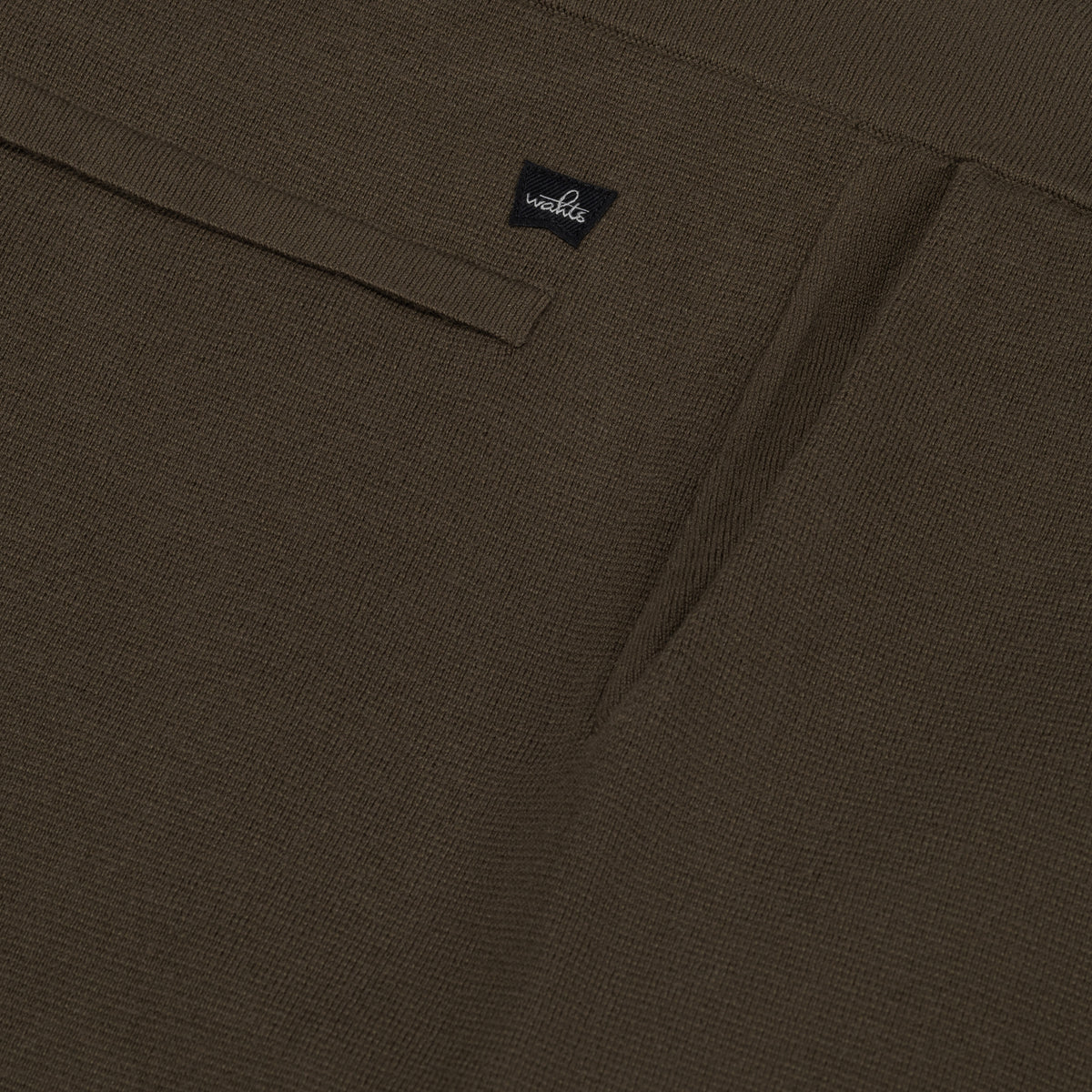 WAHTS logo label on dark olive knitted lounge pants waistband