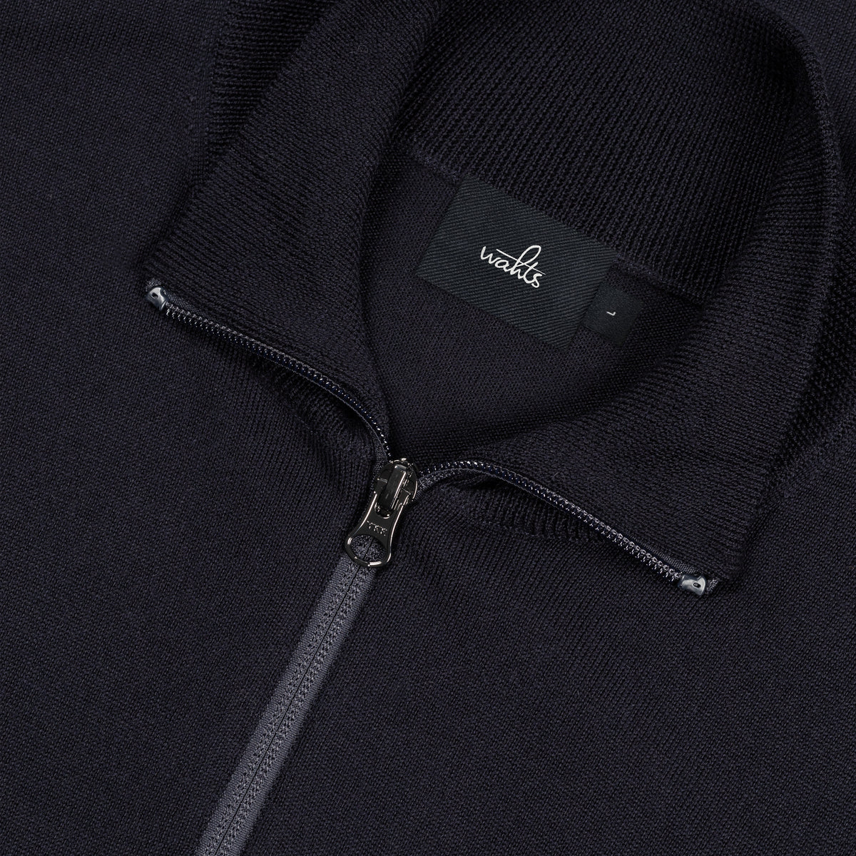 Dark blue merino half-zip pullover detail: metal zipper and brand neck label