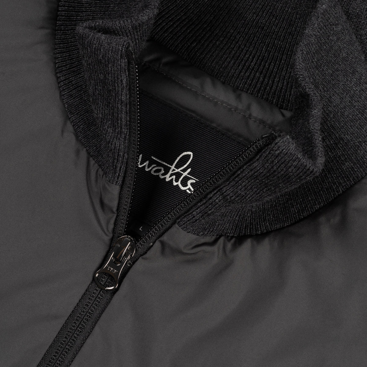 Hybrid jacket close-up: logo lining at full zip with ribbed knit trim