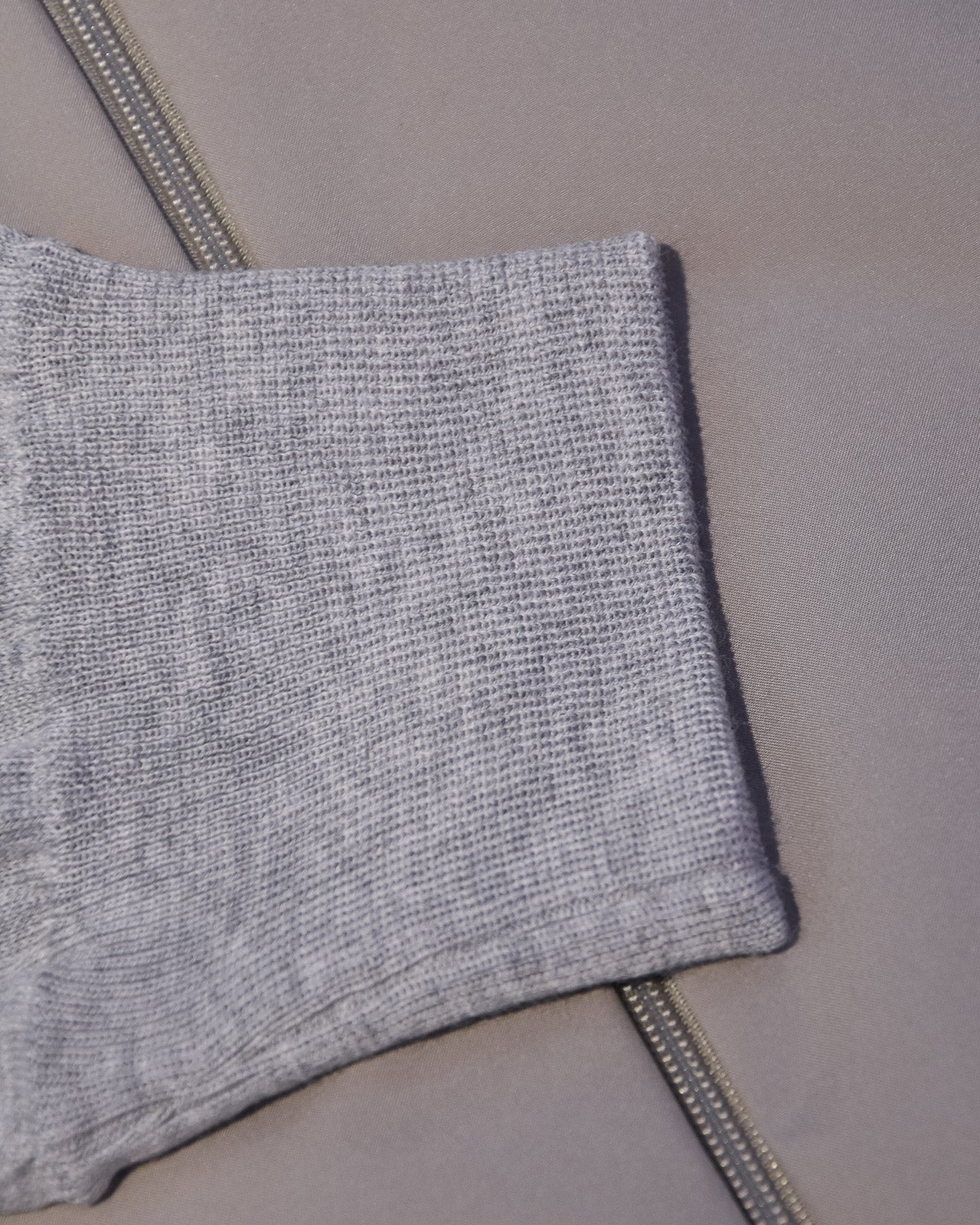 Ribbed knit hem on light grey hooded jacket