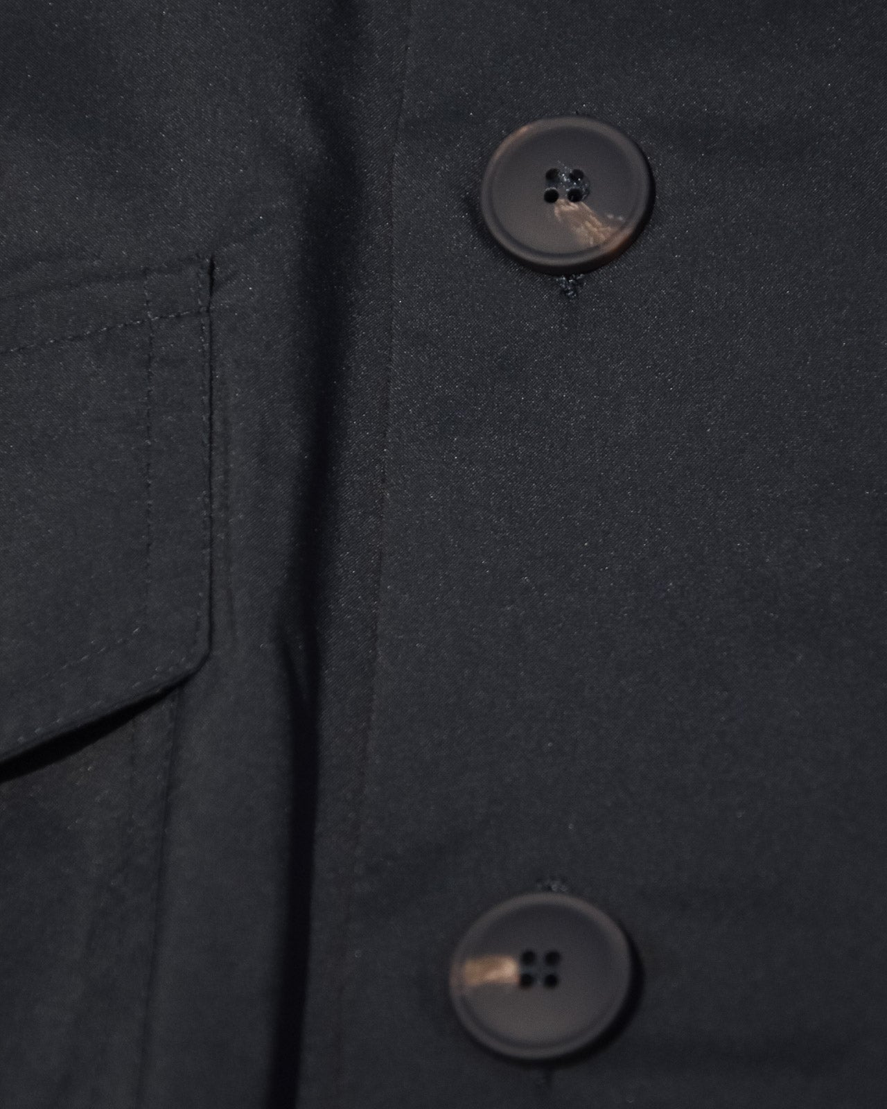 Navy tech bomber jacket close-up of black buttons