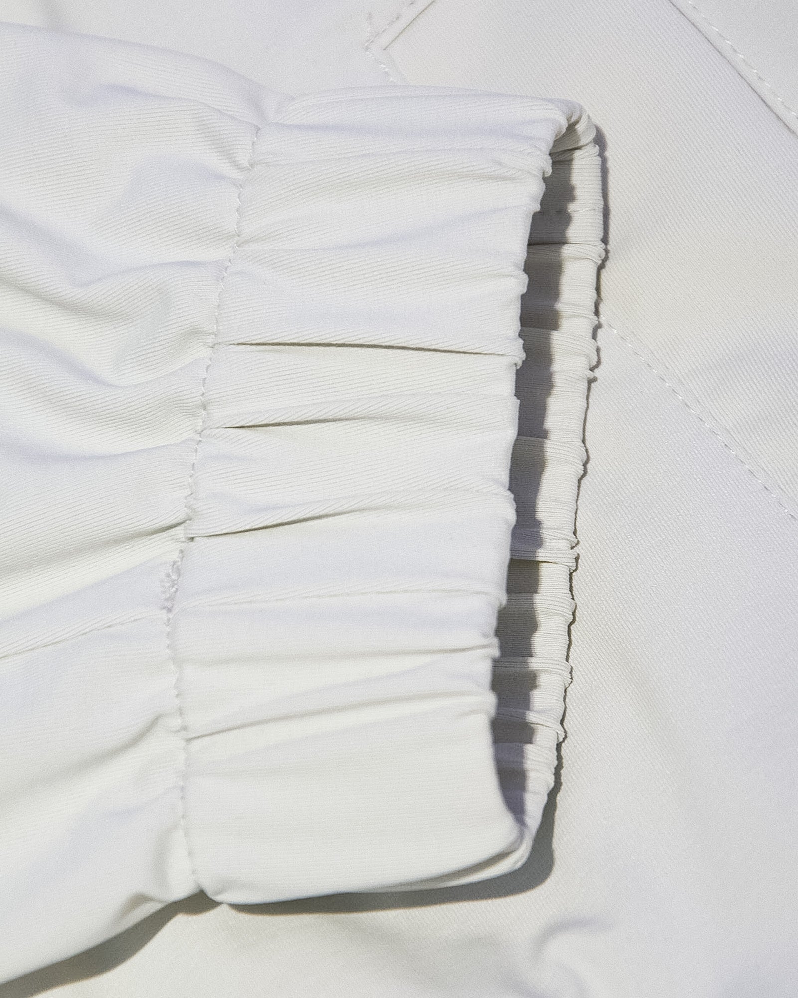 Off-white nylon hood drawstring and seam detail with elastic ruching