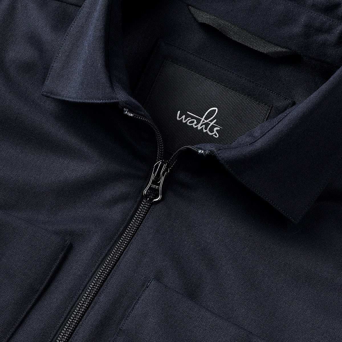 Deep navy soft wool shirt jacket close-up with zip, collar seam, and WAHTS logo tag