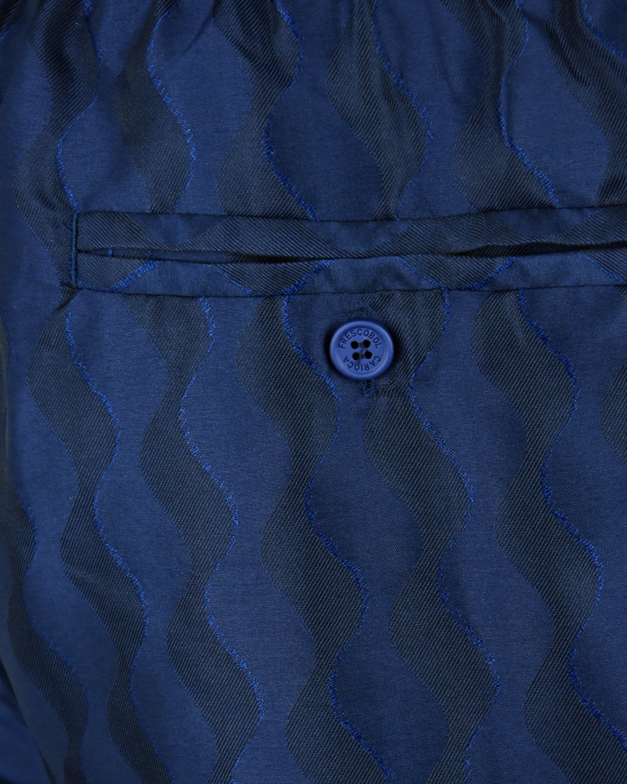 Navy swim short waistband with stitched trim and round logo tag
