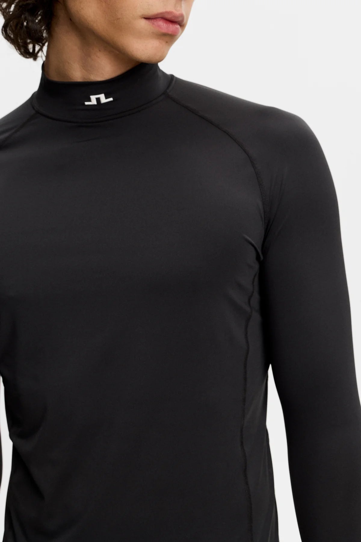 Black compression long-sleeve mock-neck top with subtle chest branding.