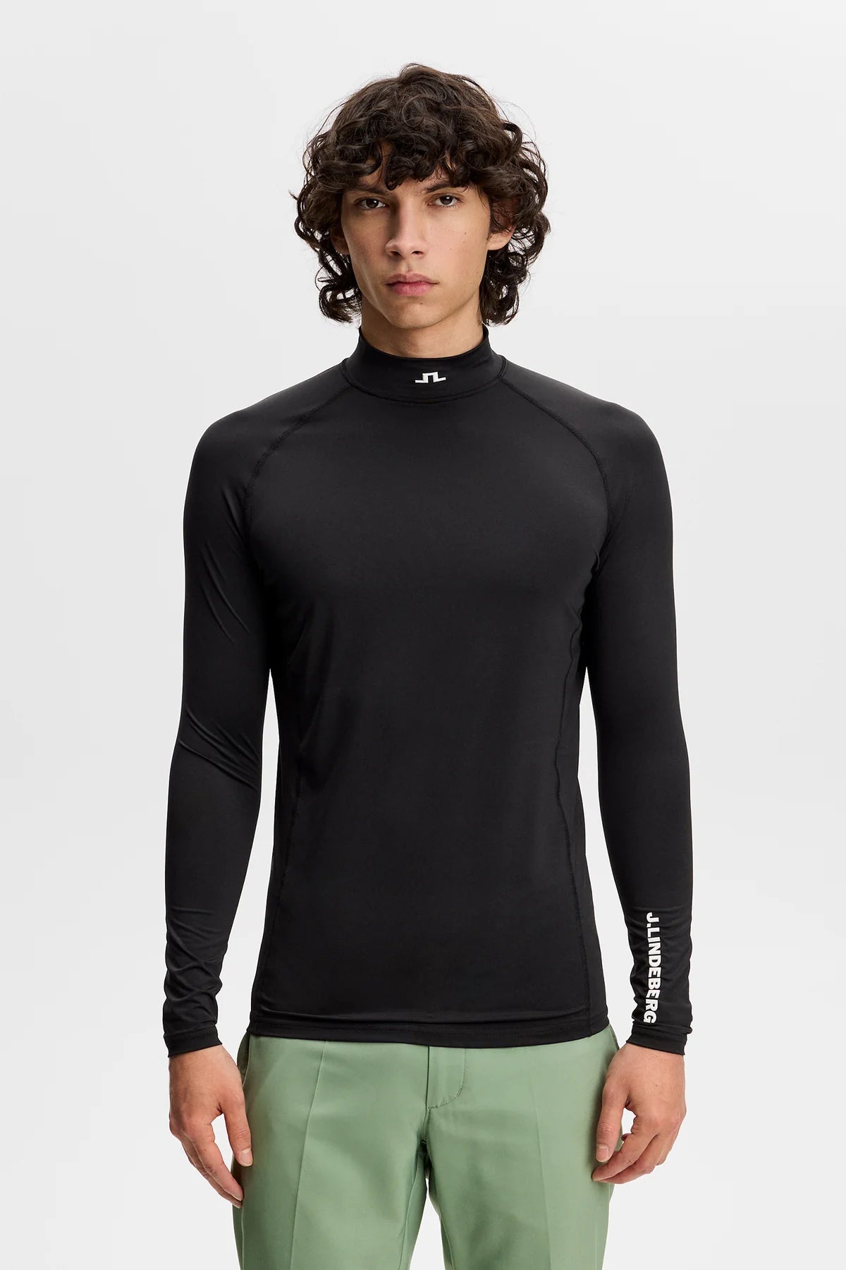 Black compression long-sleeve mock-neck top with sleeve logo detail and fitted hem.